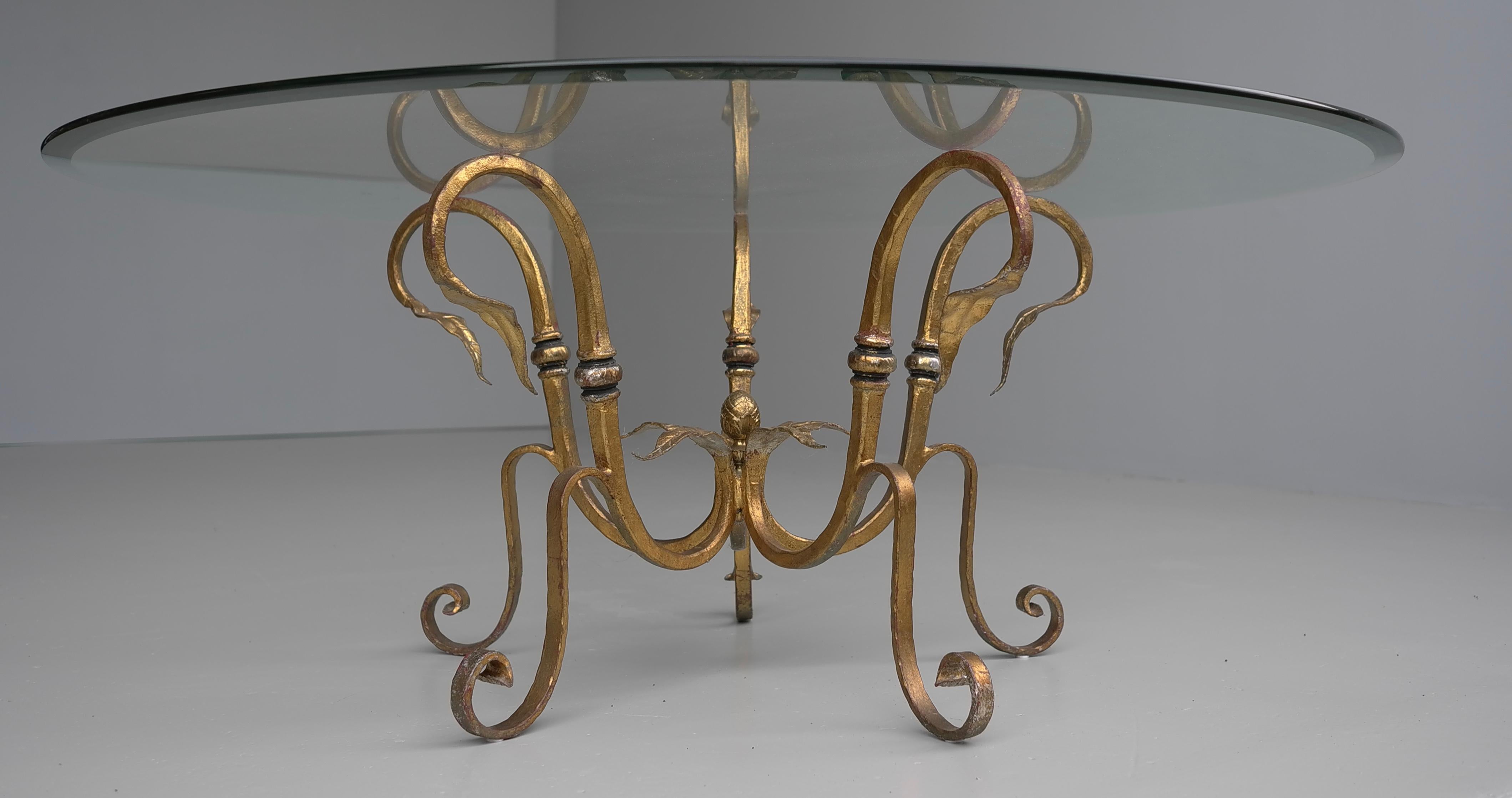 Stunning Large Gilded Iron Flower Leaf Scroll Coffee Table, France circa 1960's. This piece has has a wonderful distressed gold finish and is very heavy. The glass is very thick and looks fabulous with the sculptural iron base.