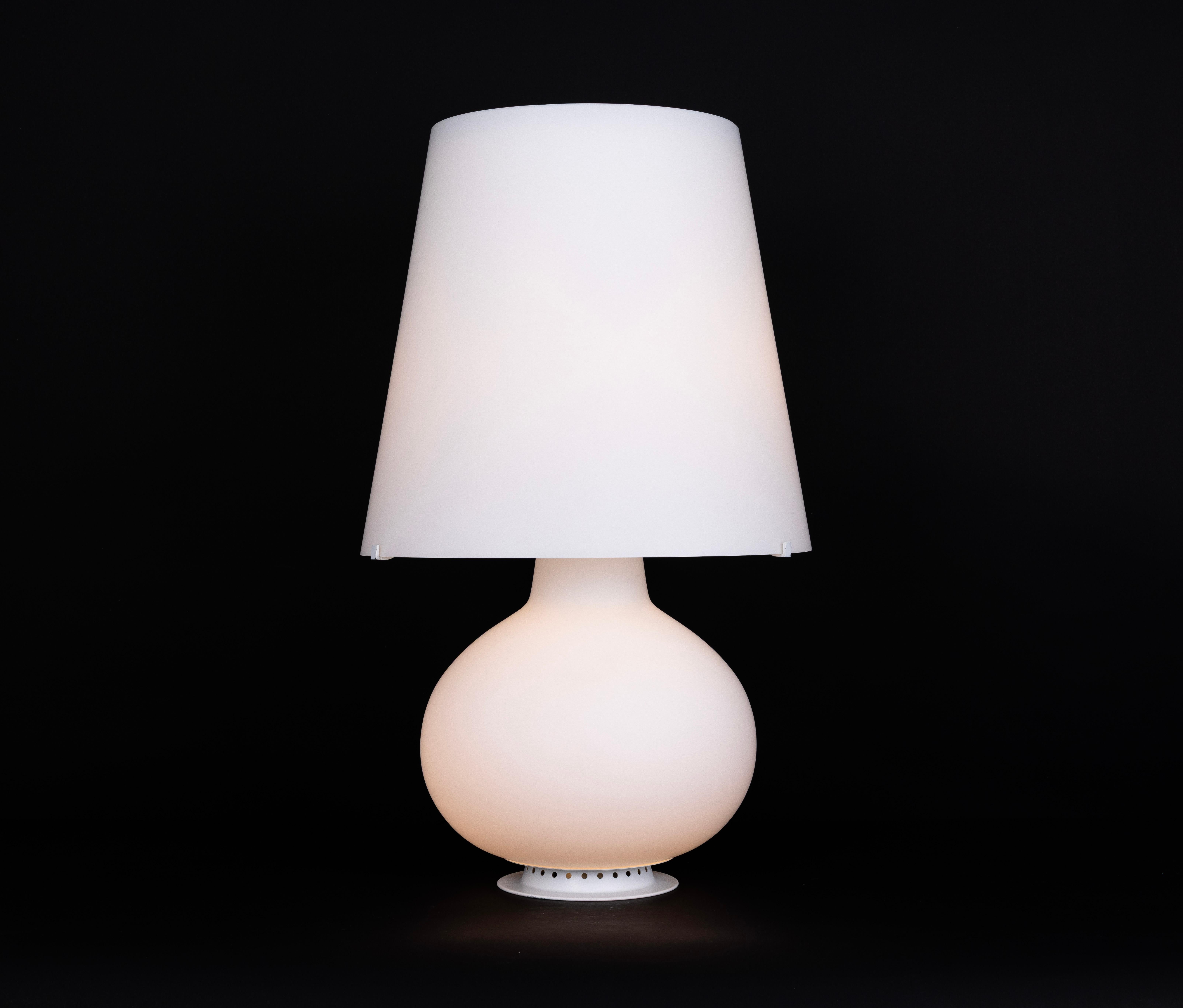 Max Ingrand Model 1853 Table Lamp for Fontana Arte – Large Version

This lamp is a timeless design classic by Max Ingrand for Fontana Arte.
It features a white satin-blown glass shade in a truncated cone shape and a frosted glass bottle-shaped base,