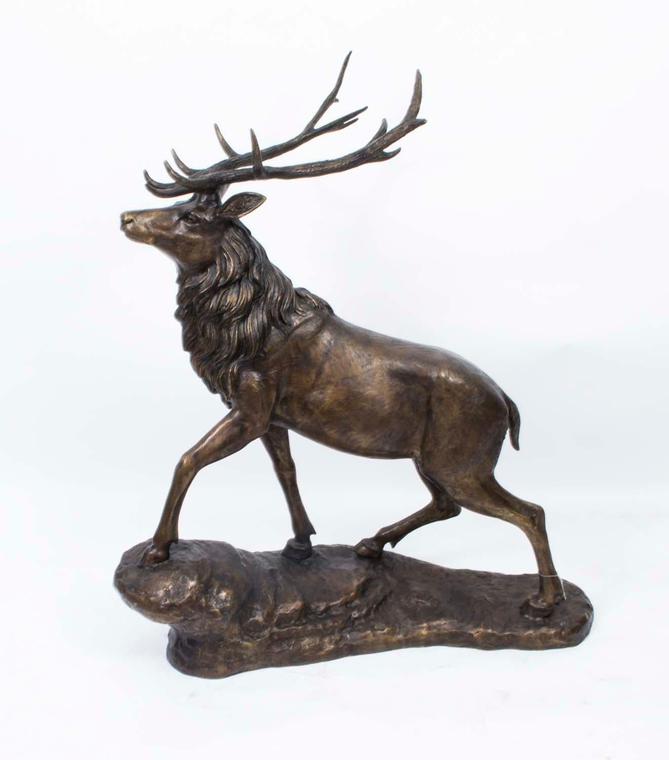 This is a very lifelike monumental bronze sculpture of a proud stag, standing on a mountain sloped base, dating from the last quarter of the 20th century.

He has a dark brown patina with detailed textured hair and horns.

There is no mistaking