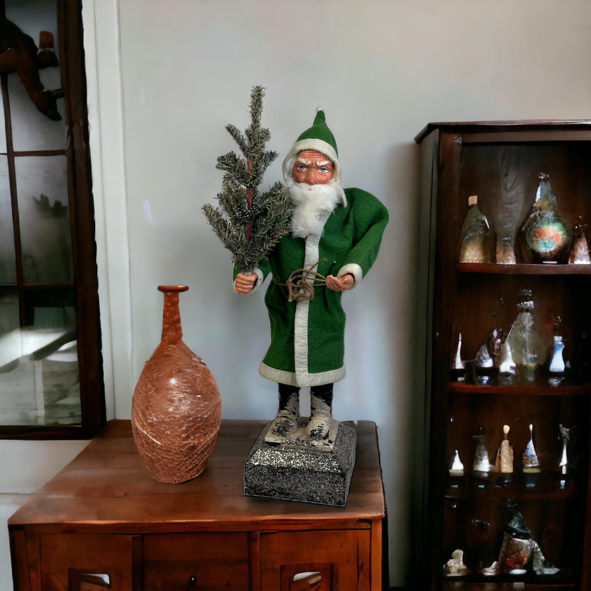 Cette boîte à bonbons vintage Belsnickle Santa Claus en composition, carton et bois a été fabriquée au 20e siècle et constitue un ajout charmant à toute collection de Noël. Réalisé en fil de fer et en papier, le sapin de Noël et le matériau