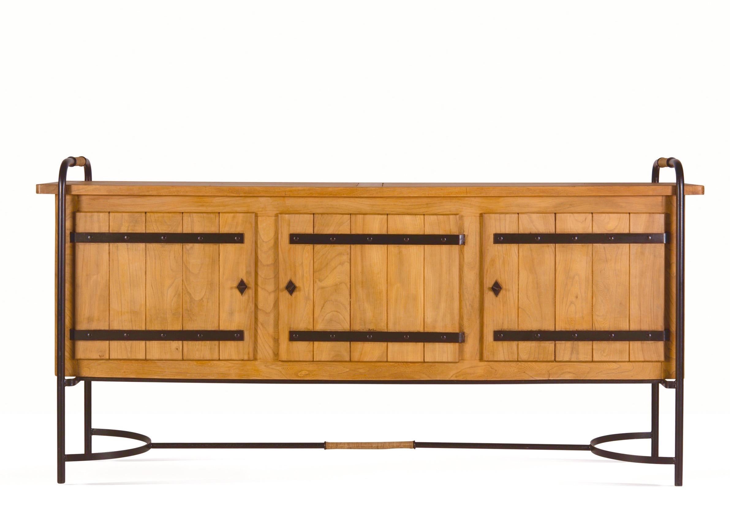 Jacques Adnet (1900–1984)

A very rare, massive, and beautiful three-door rustic sideboard by Jacques Adnet, in elm with curved wrought iron legs, equestrian nail detailing, and rattan elements on the handles and base. Three doors with original keys
