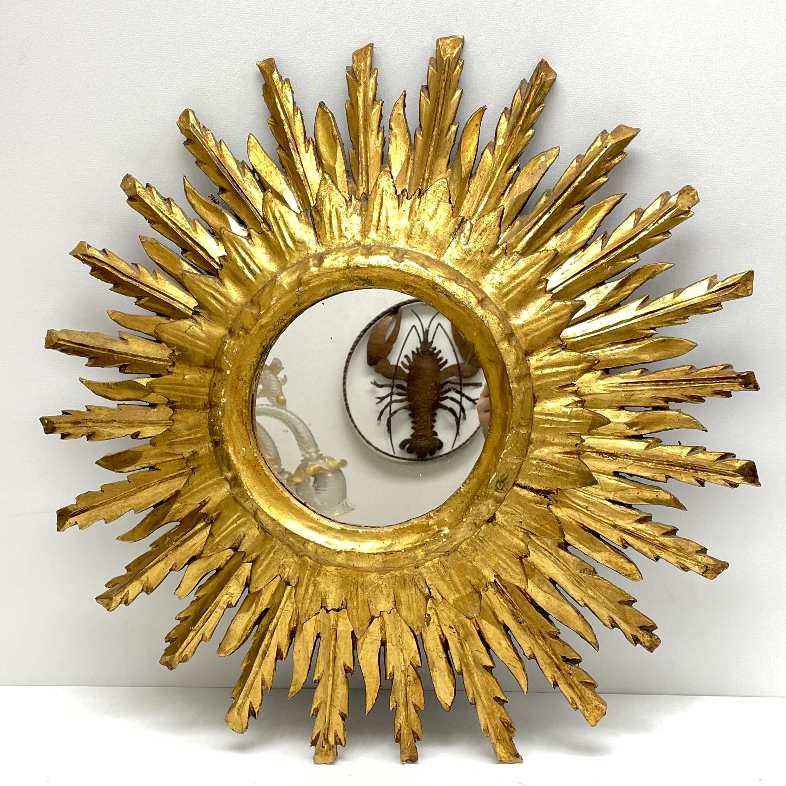 A gorgeous sunburst or starburst mirror. Made of gilded wood. It measures approximate: 23