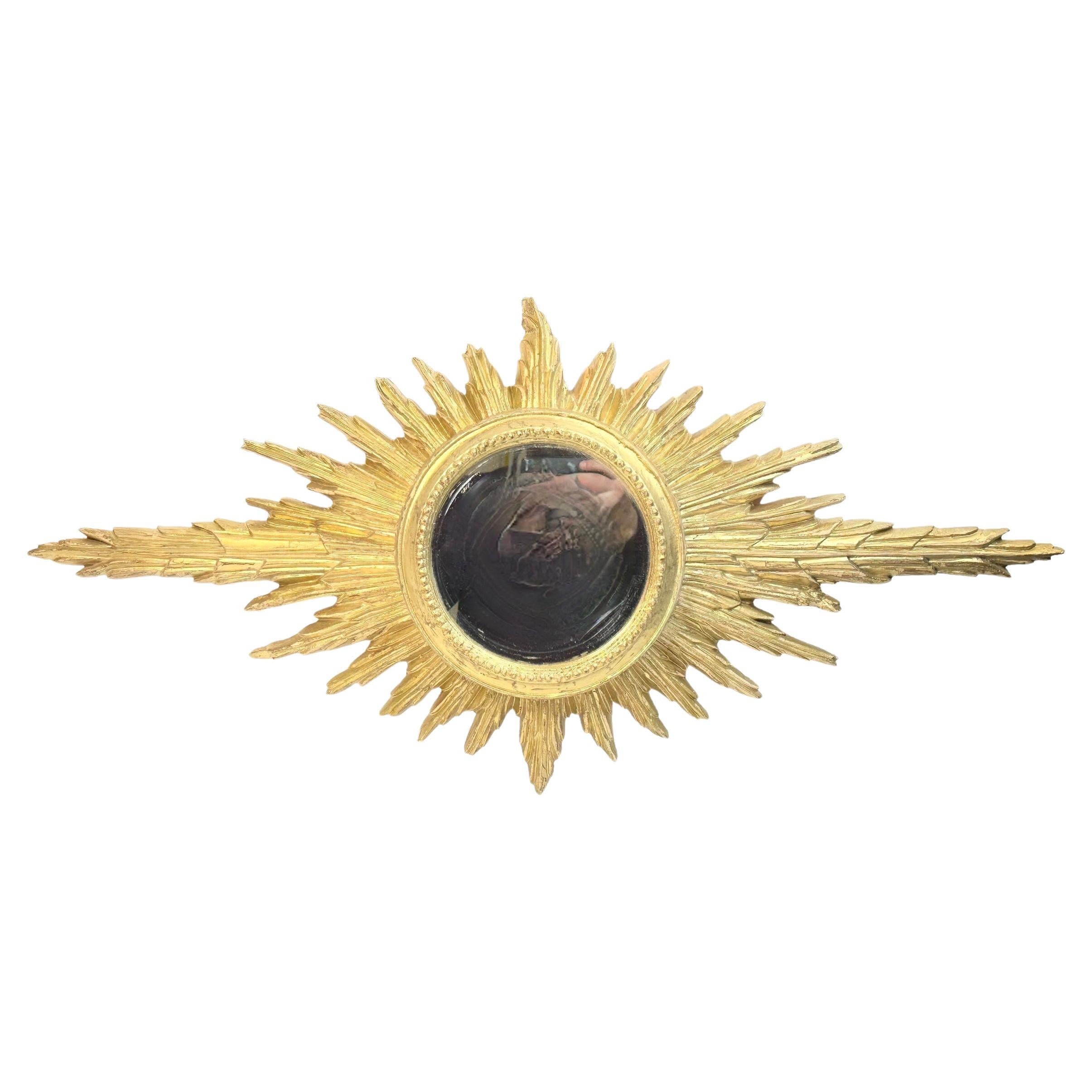 Un magnifique miroir en forme de soleil ou d'étoile. Fabriqué en bois doré. Il mesure approximativement : 36,5