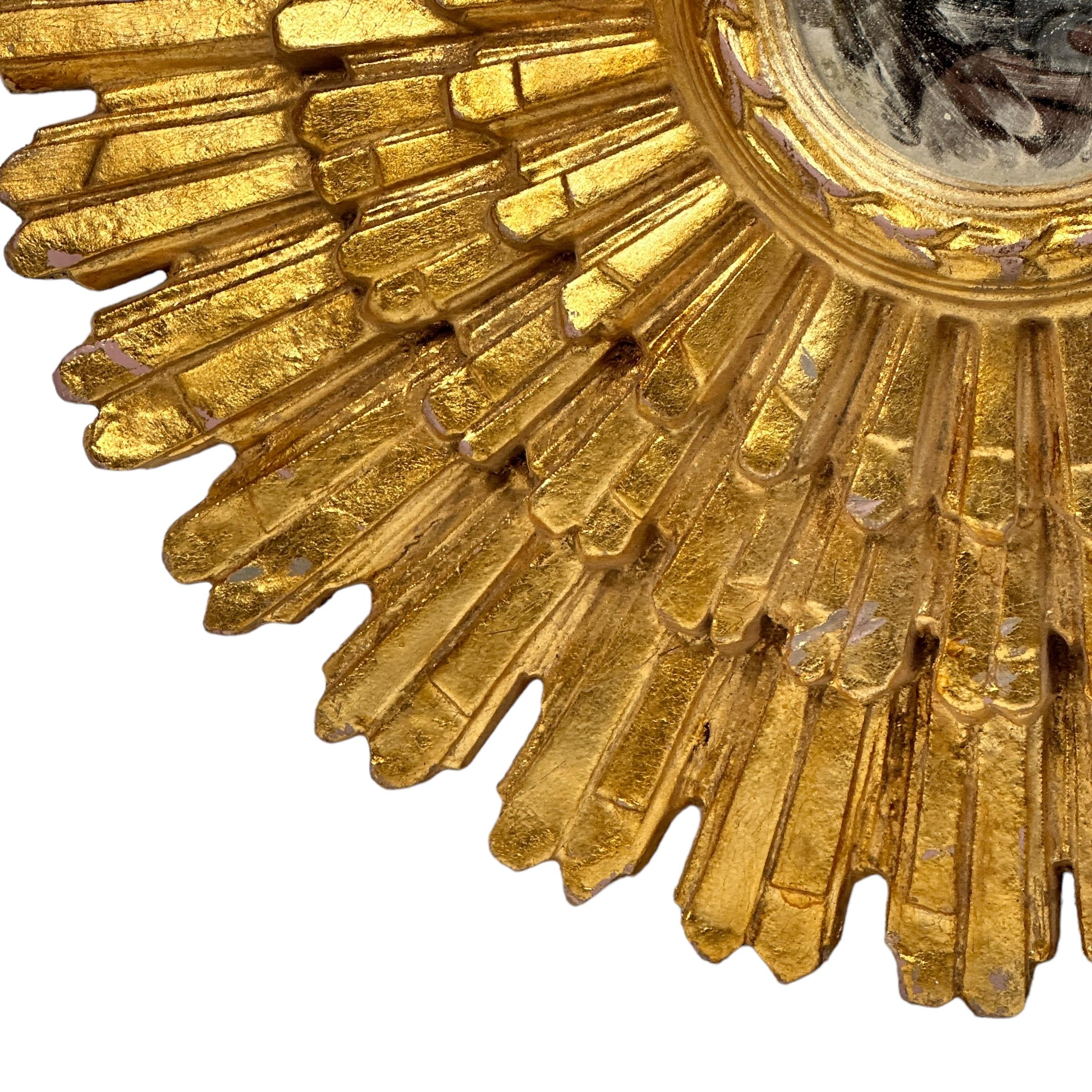 Un magnifique miroir en forme de soleil ou d'étoile. Fabriqué en bois doré. Il mesure environ 25,75 pouces de diamètre. Le miroir lui-même a un diamètre d'environ 5,13 pouces. Il se trouve à environ 3