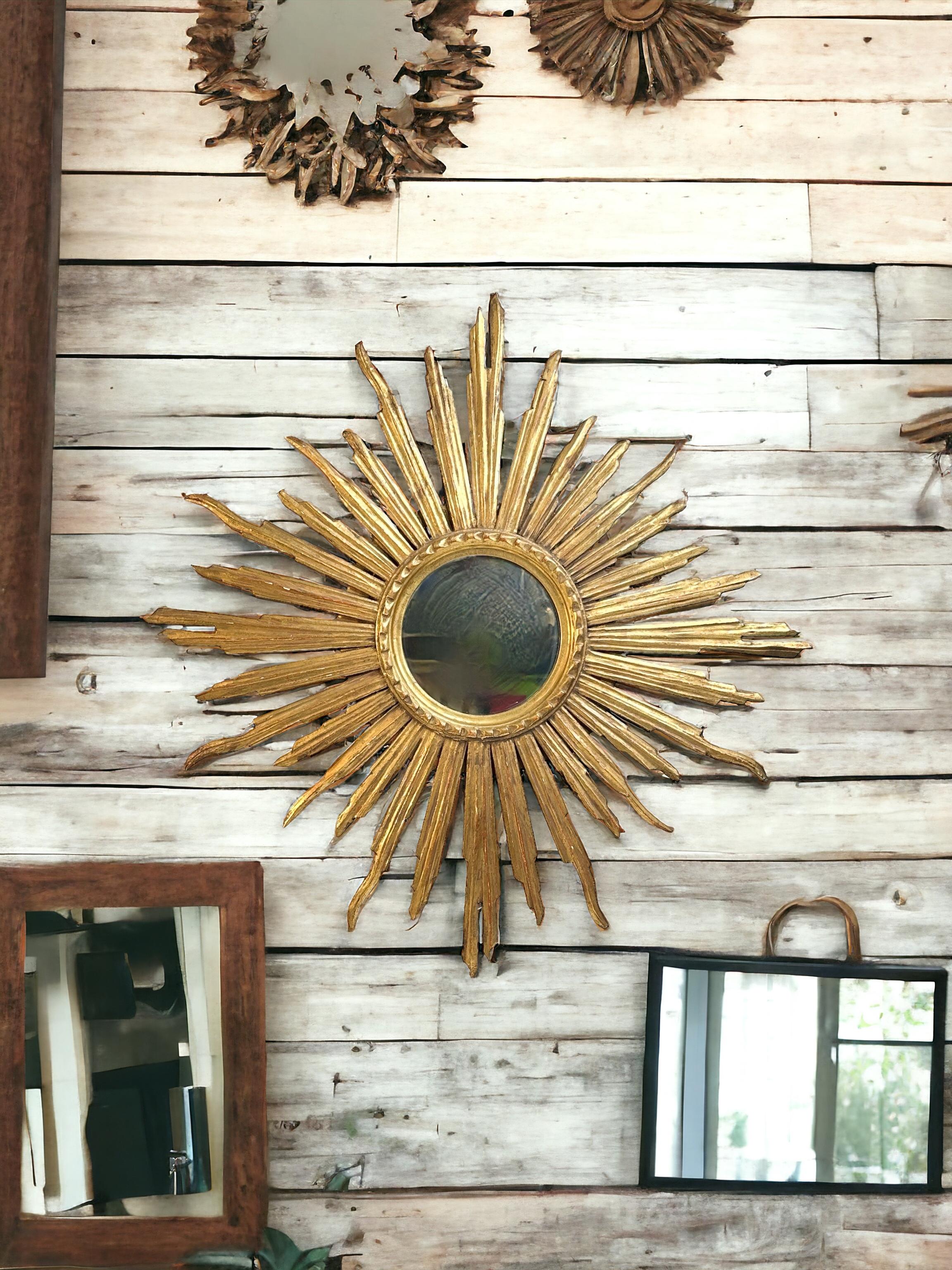 Un magnifique miroir en forme de soleil ou d'étoile. Fabriqué en bois doré. Il mesure environ 30 pouces de diamètre. Le miroir lui-même a un diamètre d'environ 7,13 pouces. Il se trouve à environ 1.5