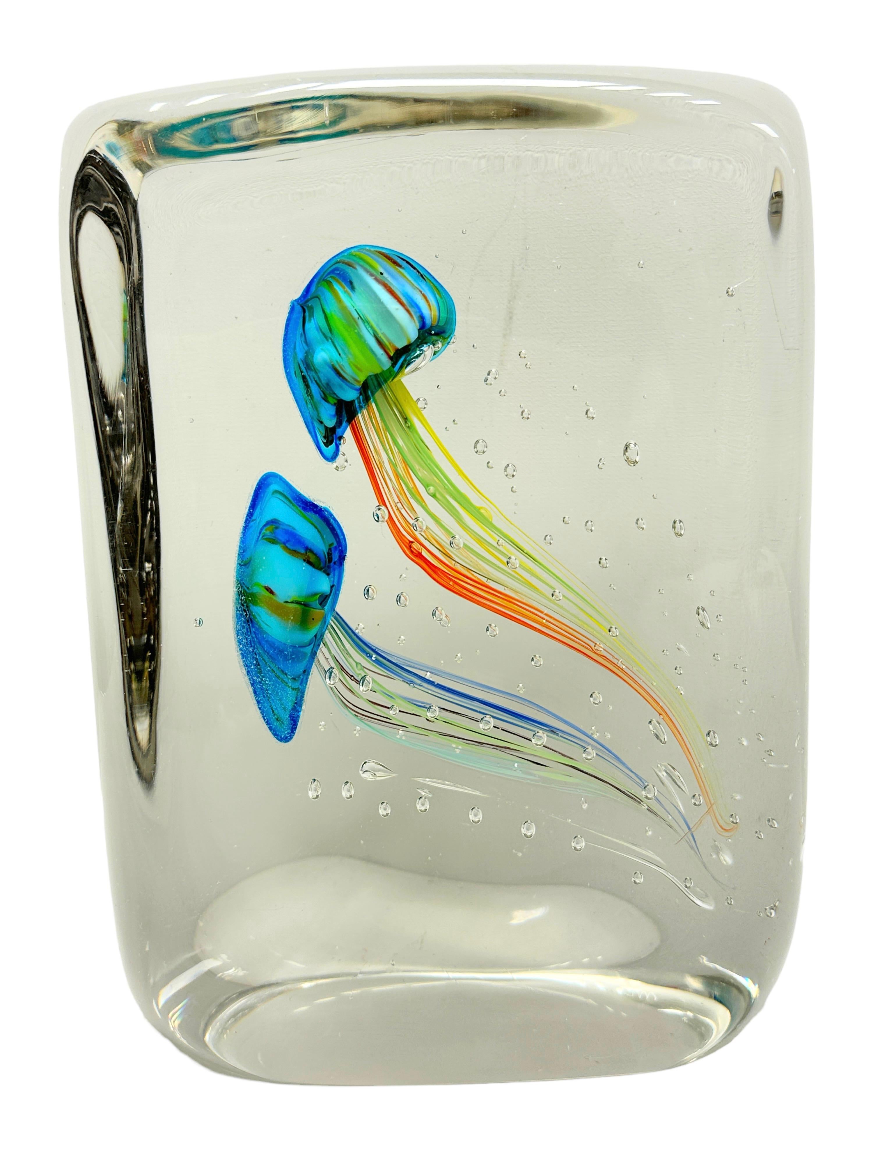 This beautiful stunning large Murano hand blown aquarium design Italian art glass sculpture was most likely made in the 1980s in Italy. It's showing two Jelly Fish inside, in two different colors, floating on controlled bubbles. 
Murano glass is a