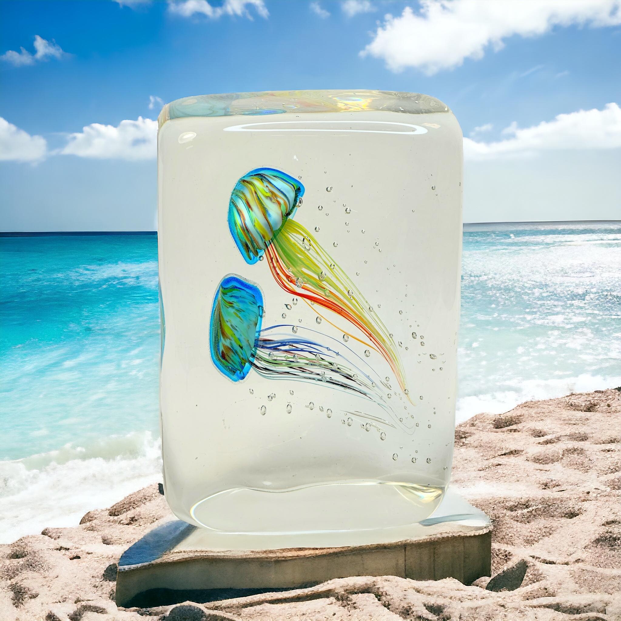 This beautiful stunning large Murano hand blown aquarium design Italian art glass sculpture was most likely made in the 1980s in Italy. It's showing two Jelly Fish inside, in two different colors, floating on controlled bubbles. 
Murano glass is a