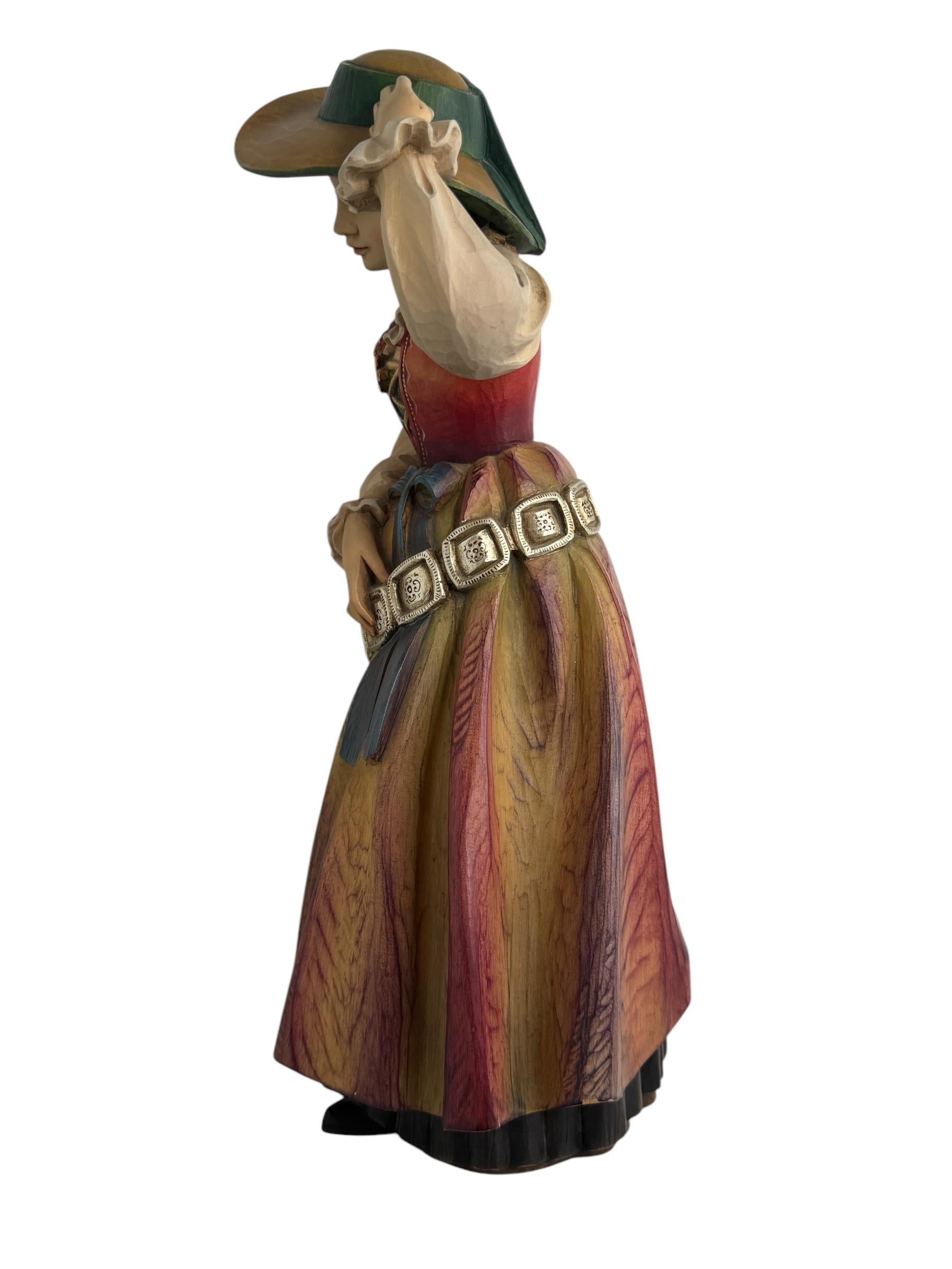 Esta talla de madera vintage de Anri es una bella obra de arte que representa a una mujer con el traje tradicional groedner o tirolés. Esta figura de madera se fabricó en los años 80 o más y es una pieza monumental de gran tamaño. Los intrincados