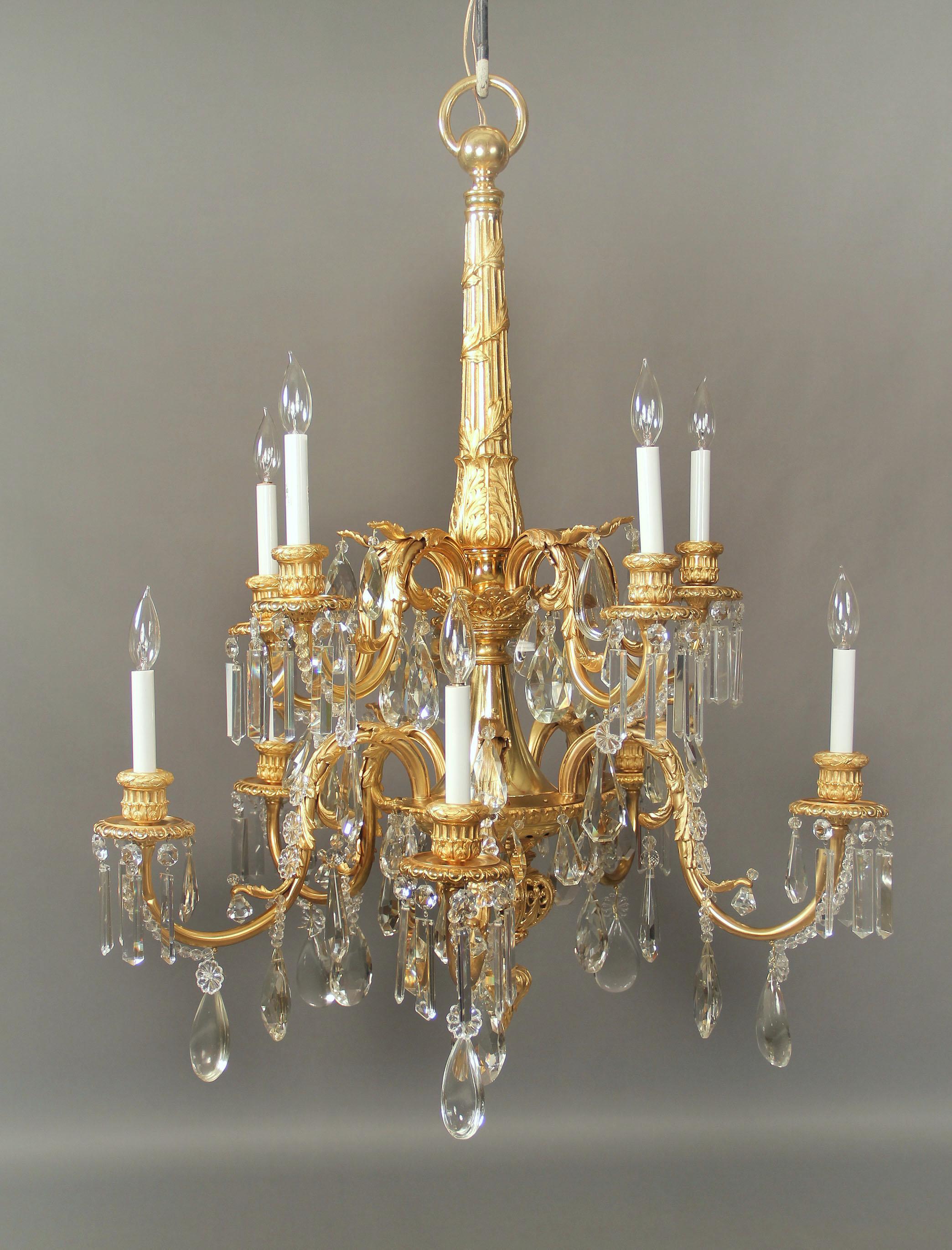 A stunning late 19th century gilt bronze and crystal ten-light chandelier.

Multifaceted and shaped crystal, an all bronze central column and neck, foliate designed arms with ten tiered perimeter lights.