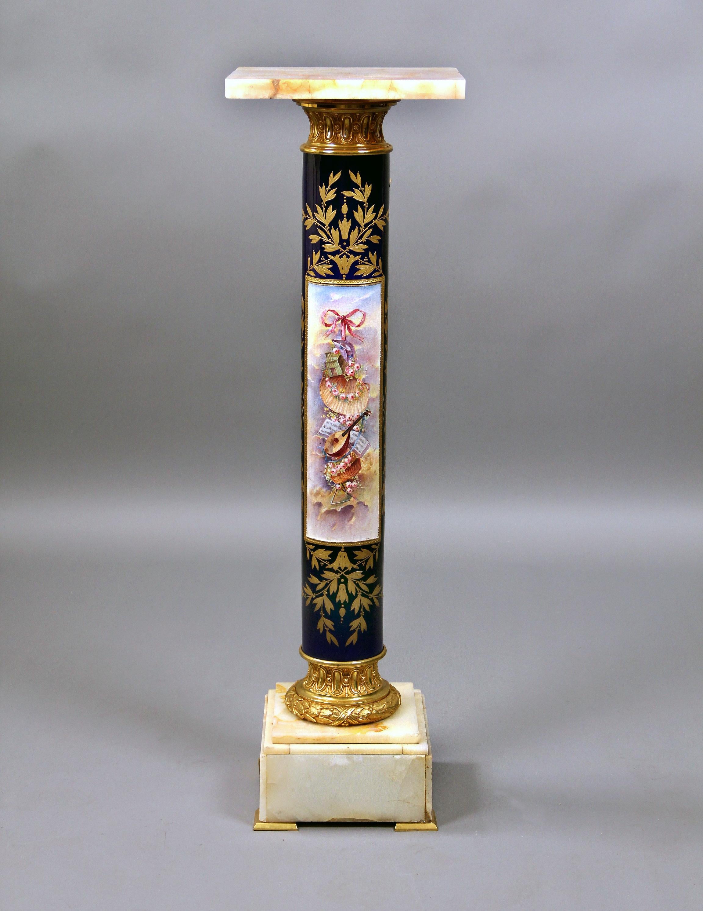 A Stunning Late 19th Century Gilt Bronze Mounted Onyx and Sèvres Style Pedestal

With square onyx top above columnar support painted with trophies in a rectangular panel flanked by scrolling gilt foliage, on a stepped onyx base.

In late 1739 –