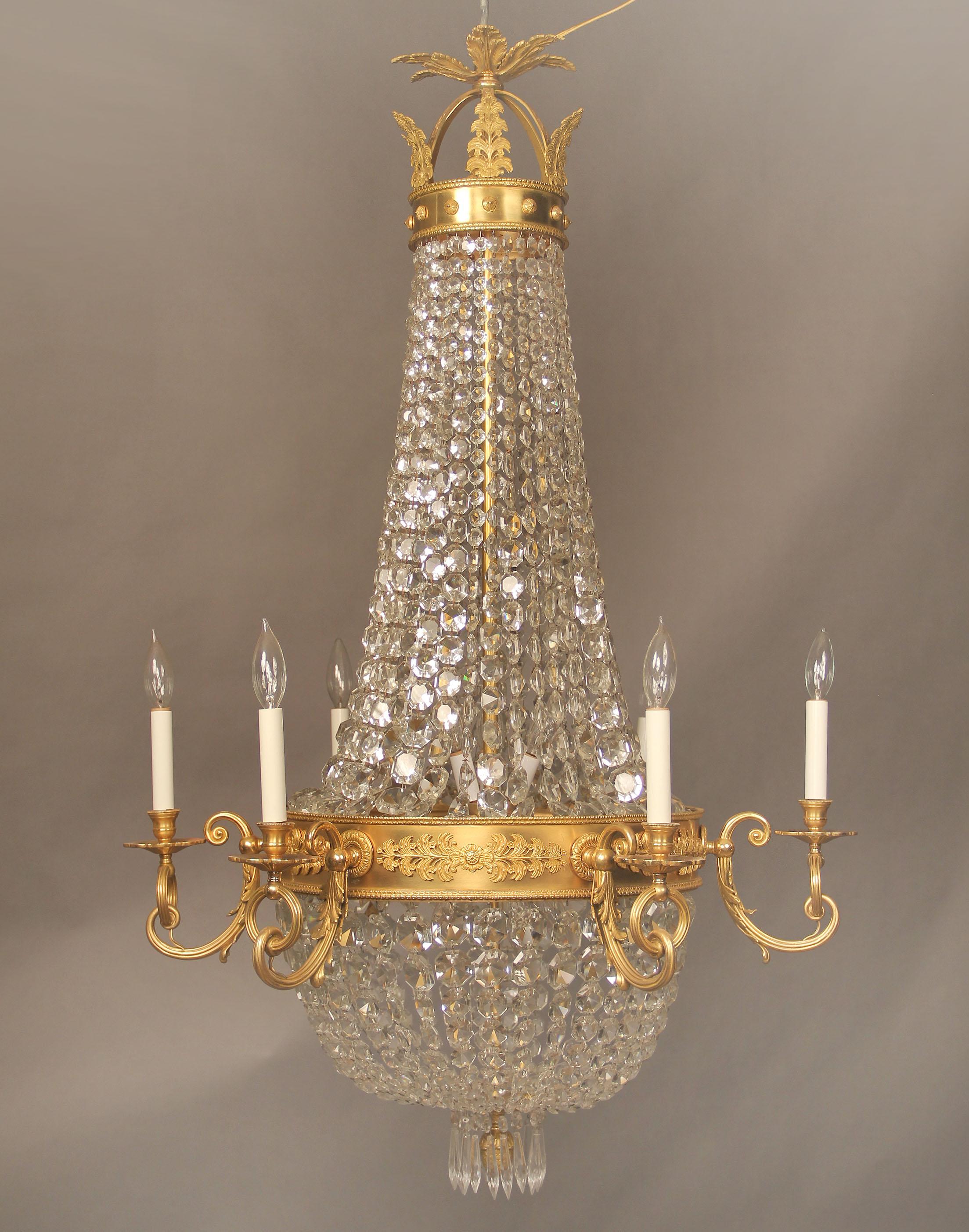 A stunning late 19th century gilt bronze and crystal Russian style fourteen-light basket chandelier.

Foliate bronze designs along the crown and arms, crystal beaded basket, six perimeter and eight interior lights.