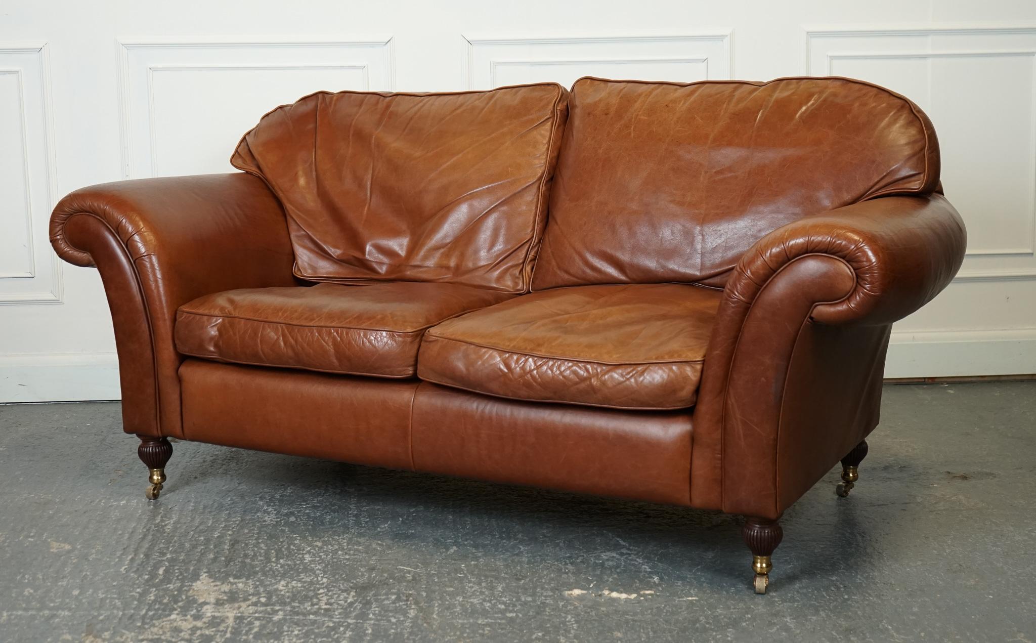 
We are delighted to offer for sale this Gorgeous Laura Ashley Mortimer Two Seater Sofa.

The stunning Laura Ashley Mortimer Medium Brown Leather Sofa is a true statement piece for any living room. Raised on castors, the sofa exudes an air of
