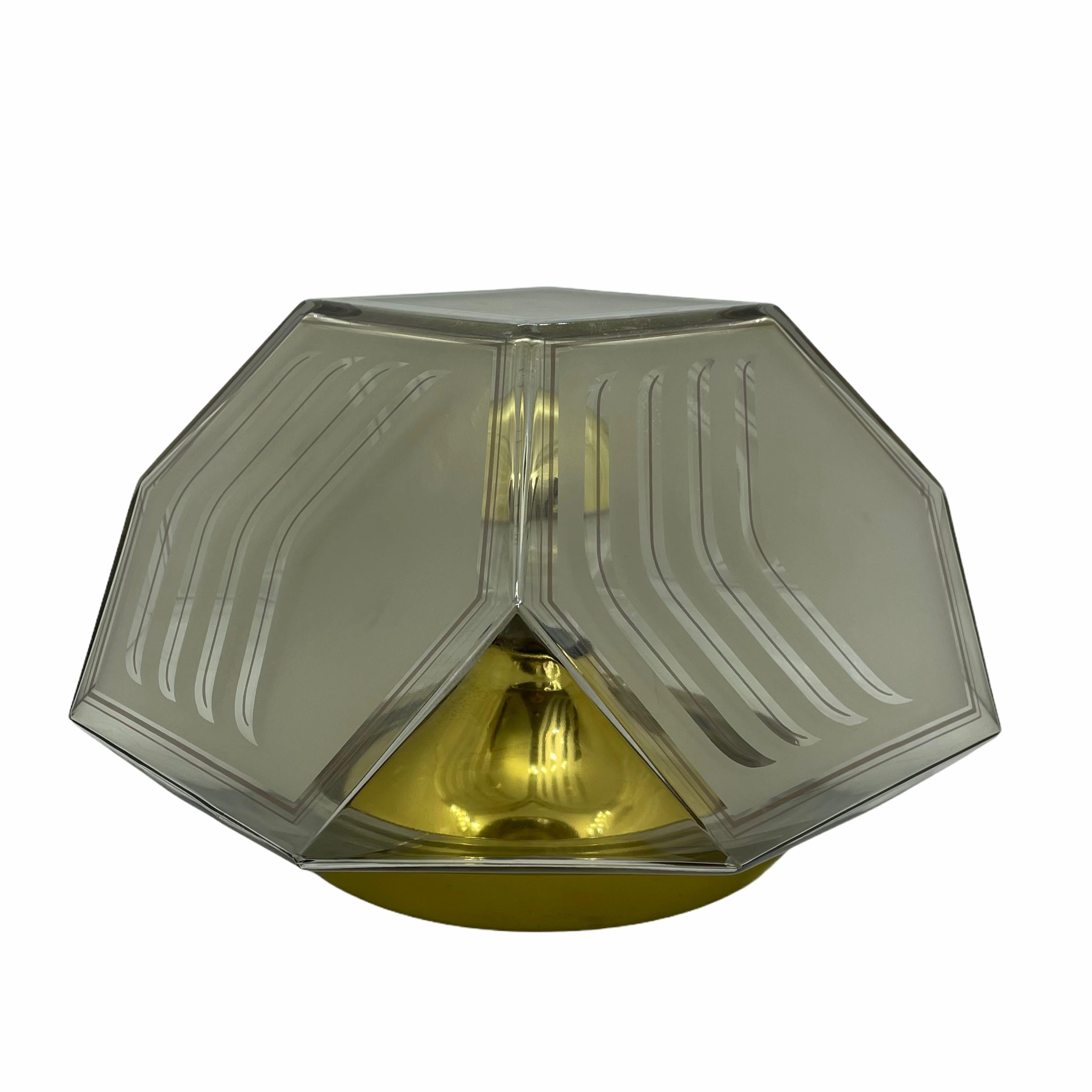 A beautiful large flush mount by German manufacturer Glashuette Limburg. The large glass element is supported by a polished brass plate with one light sources. Beautiful diamond shape smoked glass on a metal fixture. The Fixture requires one