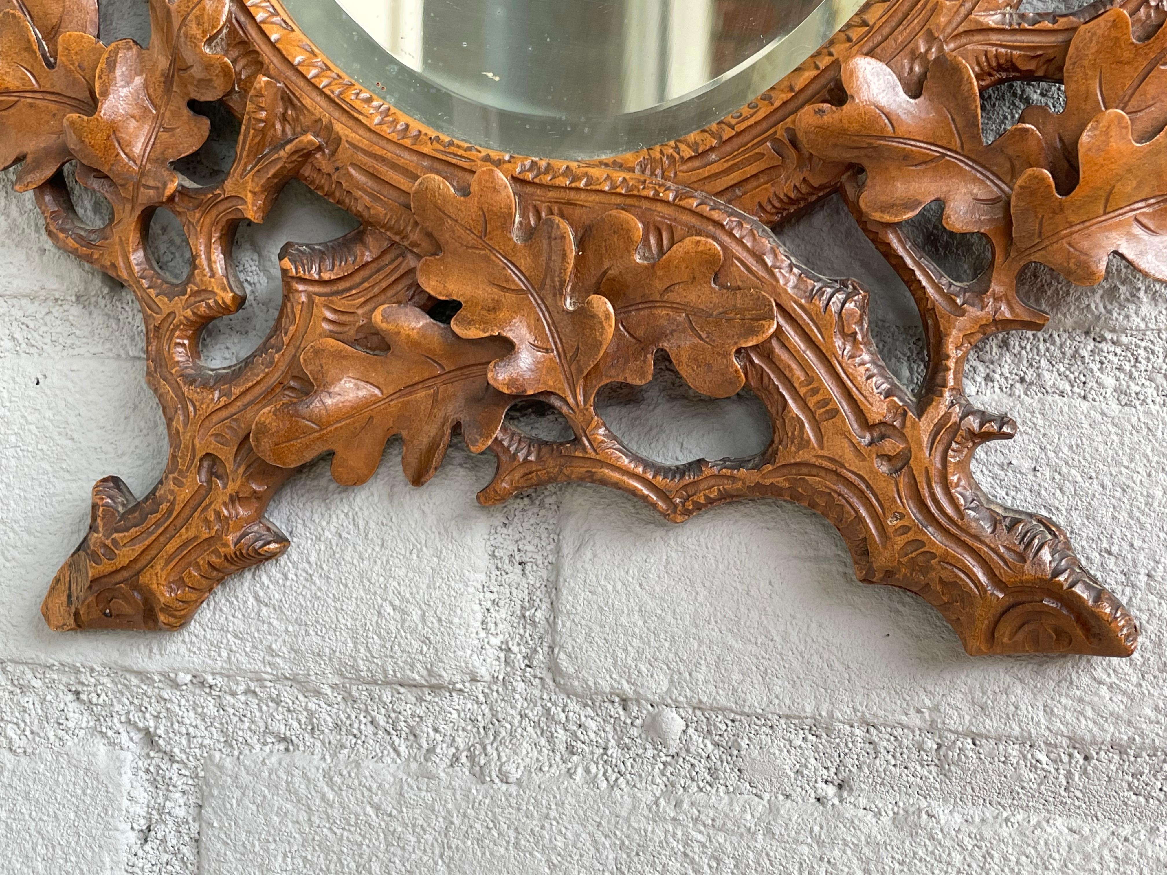 Antique and highly decorative, Swiss Black Forest antique with the original beveled mirror. 

This beautiful, early 20th century, hand carved antique mirror is in superb condition. The Swiss workmanship is of a quality and beauty that you just don't