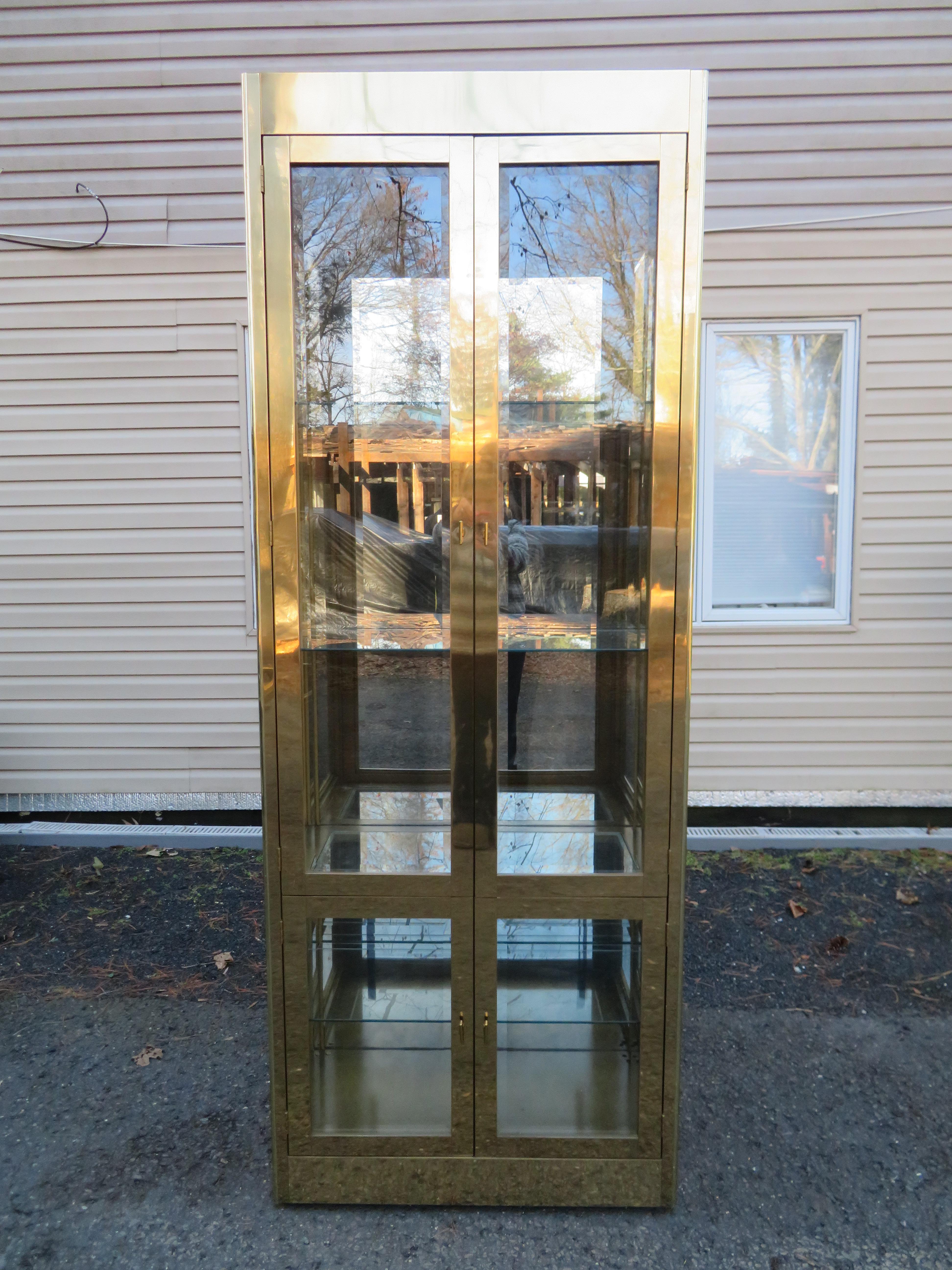 Fantastic Mastercraft brass vitrine. This magnificent vitrine has four heavy doors that open to reveal thick glass shelves with a plate ridge for displaying plates and such. This vitrine is large and impressive- make a huge statement. It measures