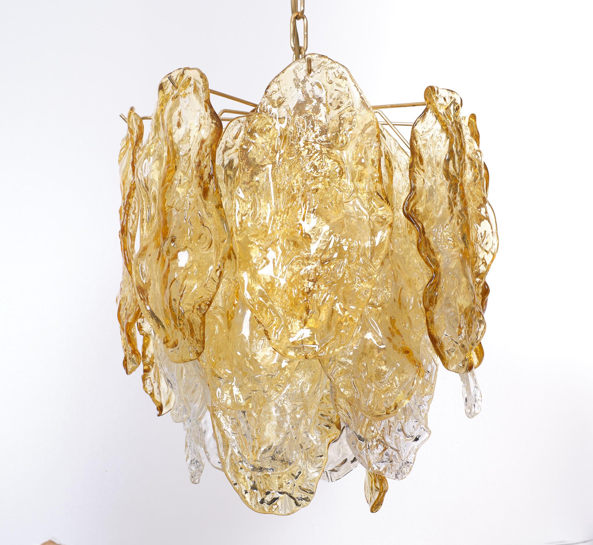 Stunning Mazzega chandelier. Brass armature, comes with 26 murano glass 
panels. Because the shape of the panels. Its create movement in the chandelier.
Also the colors gives that effect. 4 Large E27 bulbs needed. No defects. Good condition.