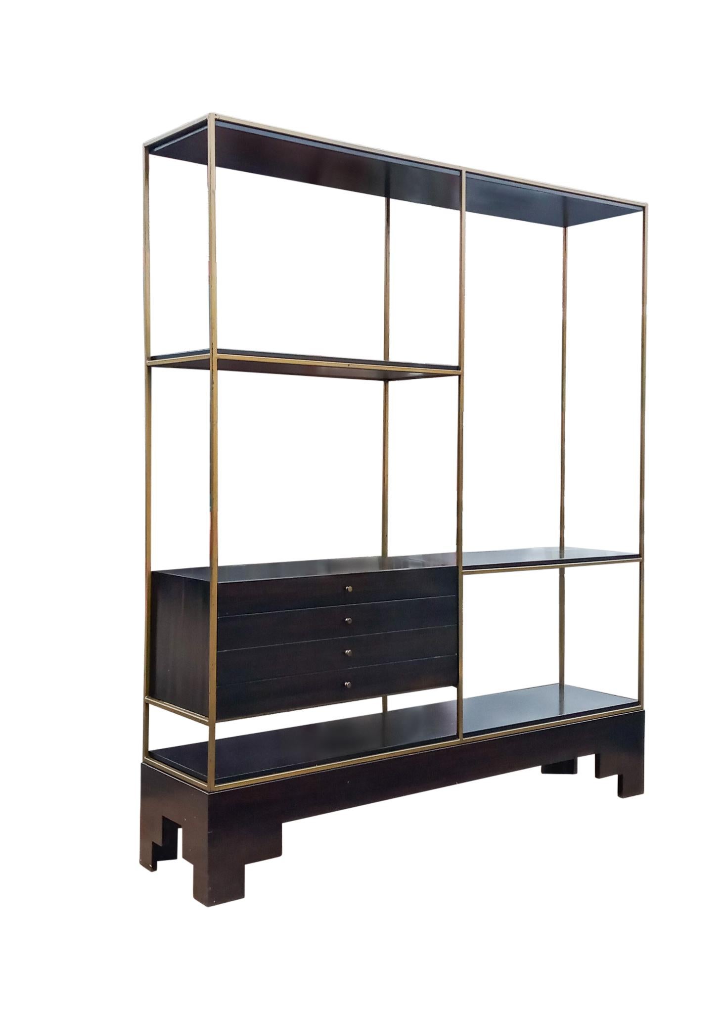 A well crafted one-piece brass frame and mahogany bookcase / room divider with fixed shelves and four upper drawers with original brass pulls. The lower base is custom made to match and allows flexible use in your home. The piece retains the