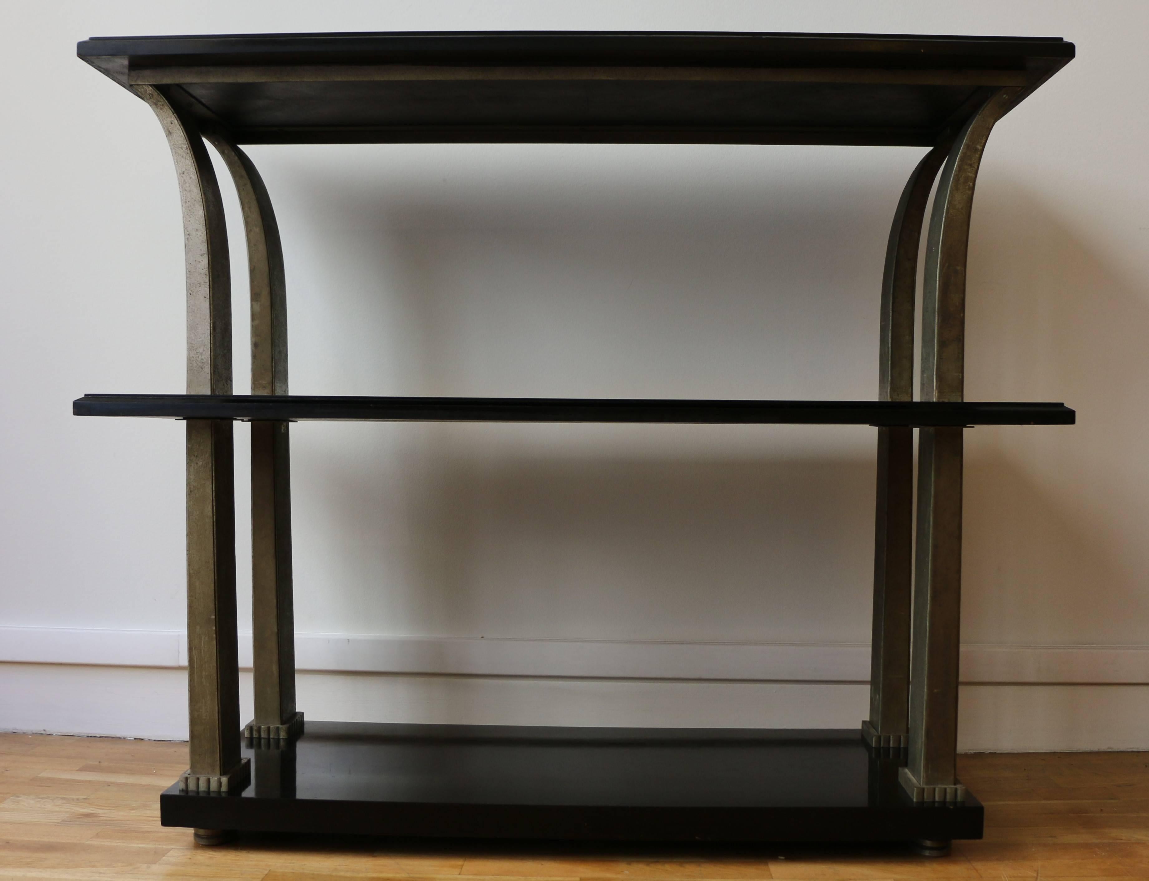 Console with three shelves/trays by Edgar Brandt (1880-1960). The shelves are made of black relacquered wood. The four squared legs are made of hammered metal in a palm shape.
Stamped on a leg: 