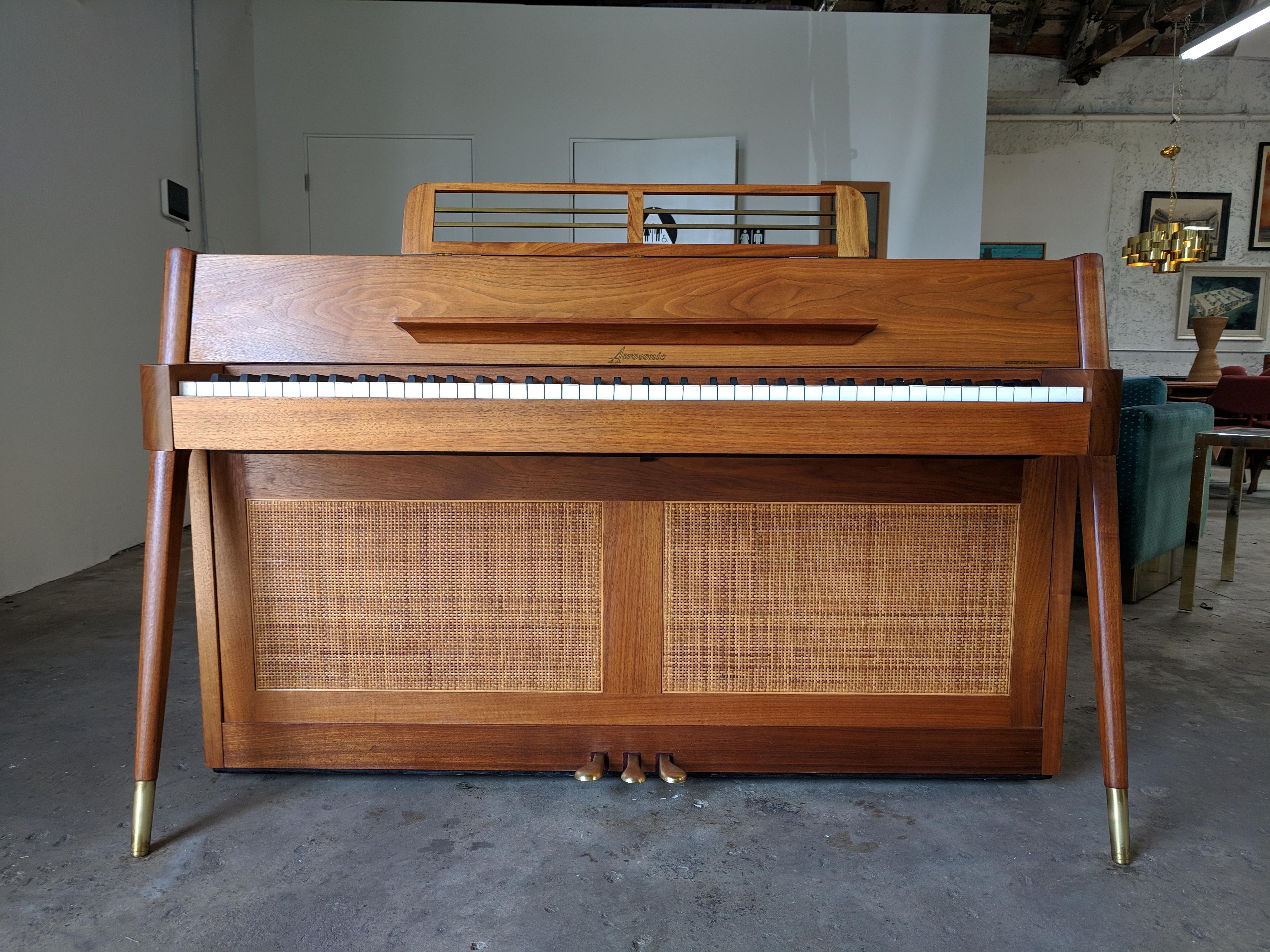 Beautiful grain. Walnut with brass tipped angled legs. Cane on the front and the back. Includes original care instructions and 10 year warranty pamphlet, which has since expired. Sounds great. Has a rare bench. Some of the keys have notes written on