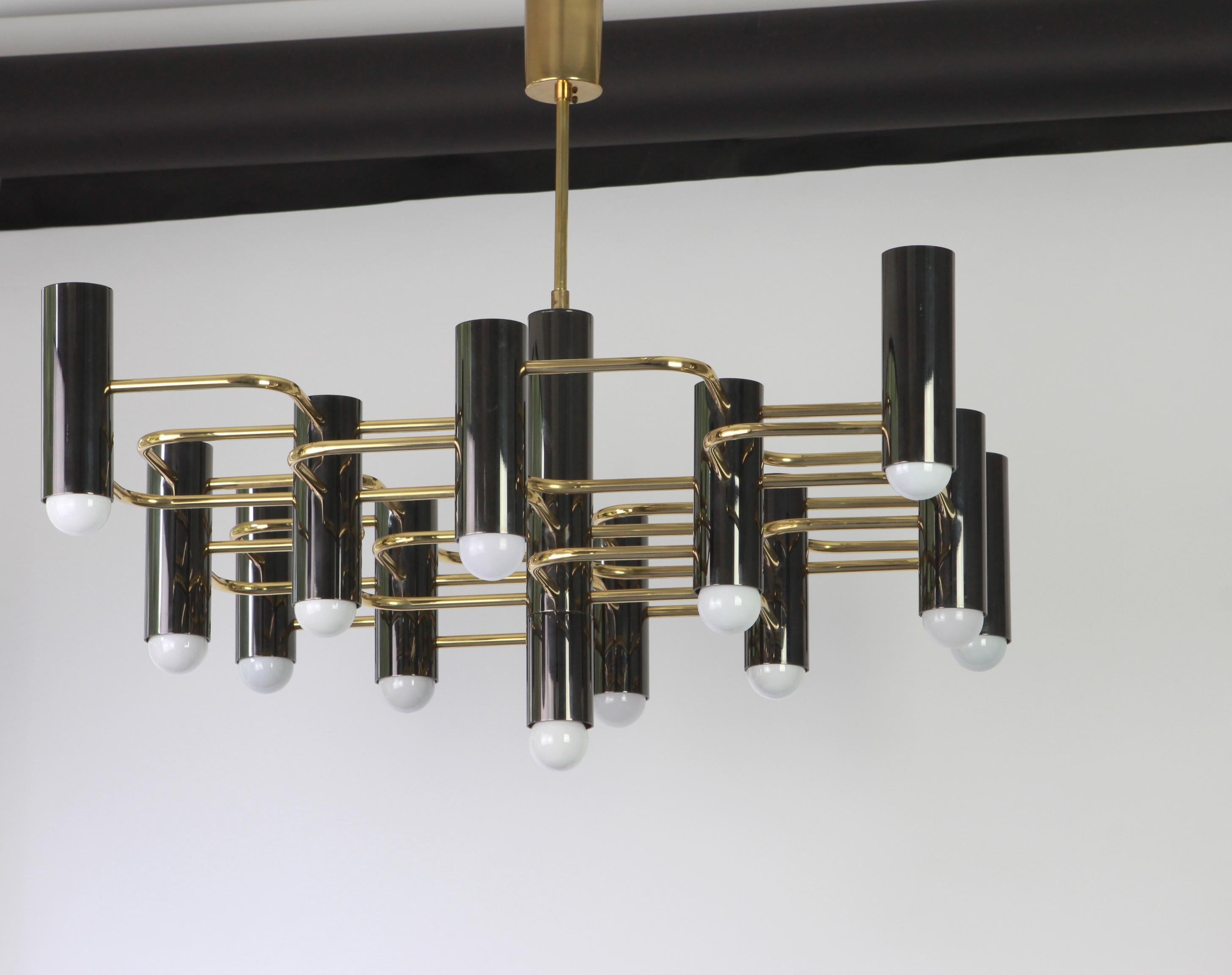 Stunning thirteen-light chandelier in brass and black metal, designed by Sciolari in the 1970s.
Great geometrical shape.
Very good condition.
Sockets: 13 x E14 small bulbs.
The height can be adjusted for a higher or lower ceiling.

  