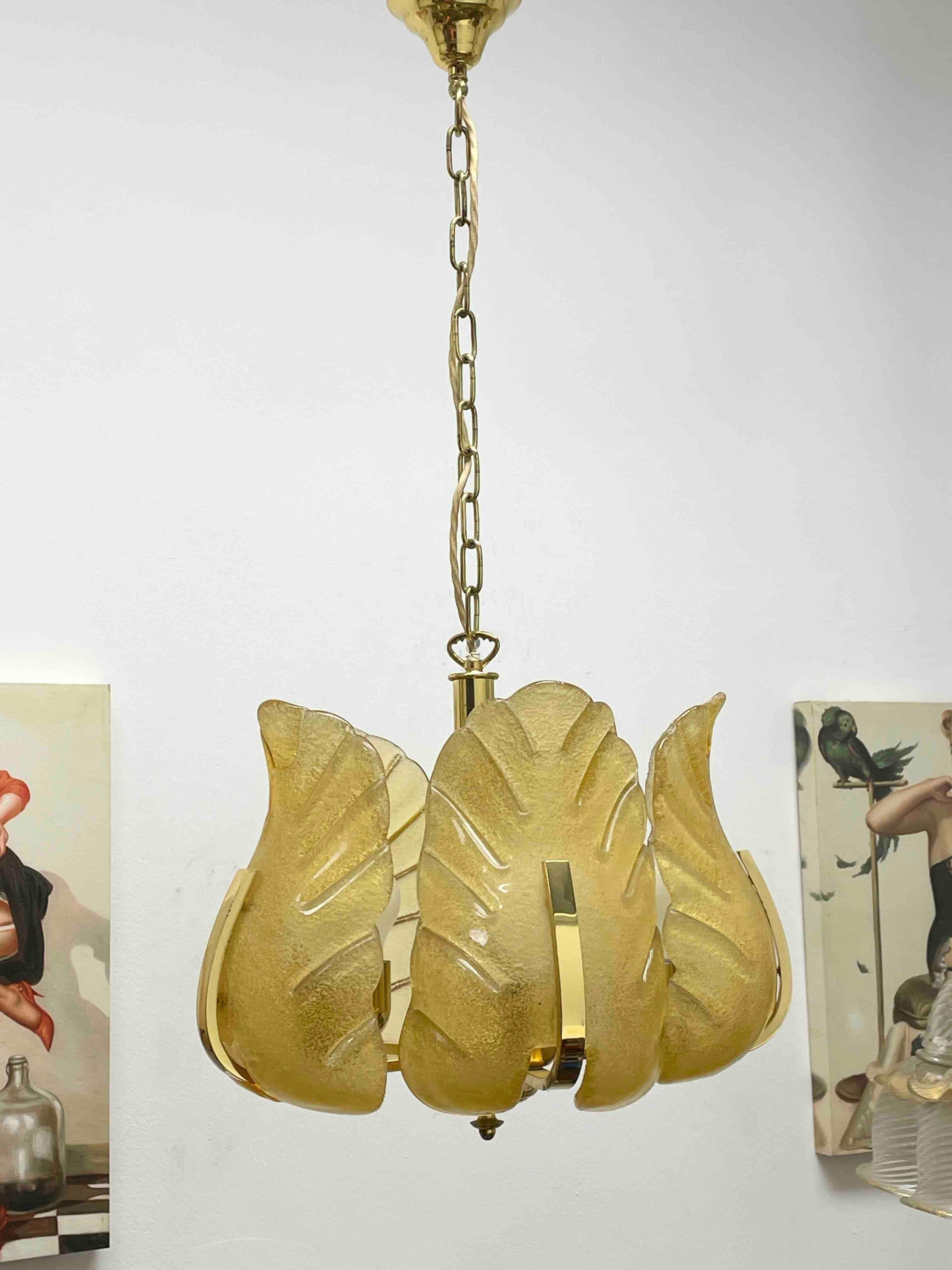 Beautiful chandelier designed by Carl Fagerlund for Orrefors, Sweden. This light fixture is made of metal, brass and lovely elements of glass in the style of leafs. Gorgeous Scandinavian lamp with Murano glass and brass, in very good vintage