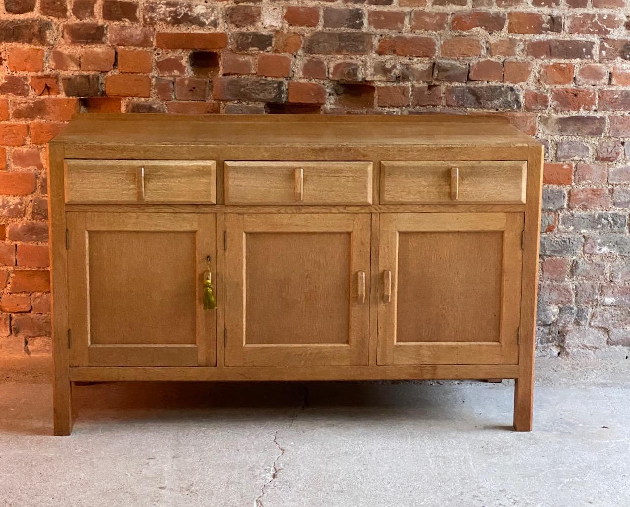 Magnificent mid-20th century Heals blonde oak sideboard buffet circa 1950, the rectangular top with back lip over three frieze drawers drawers with upright drawer handles above three panelled cupboards two with internal shelving, the left cupboard