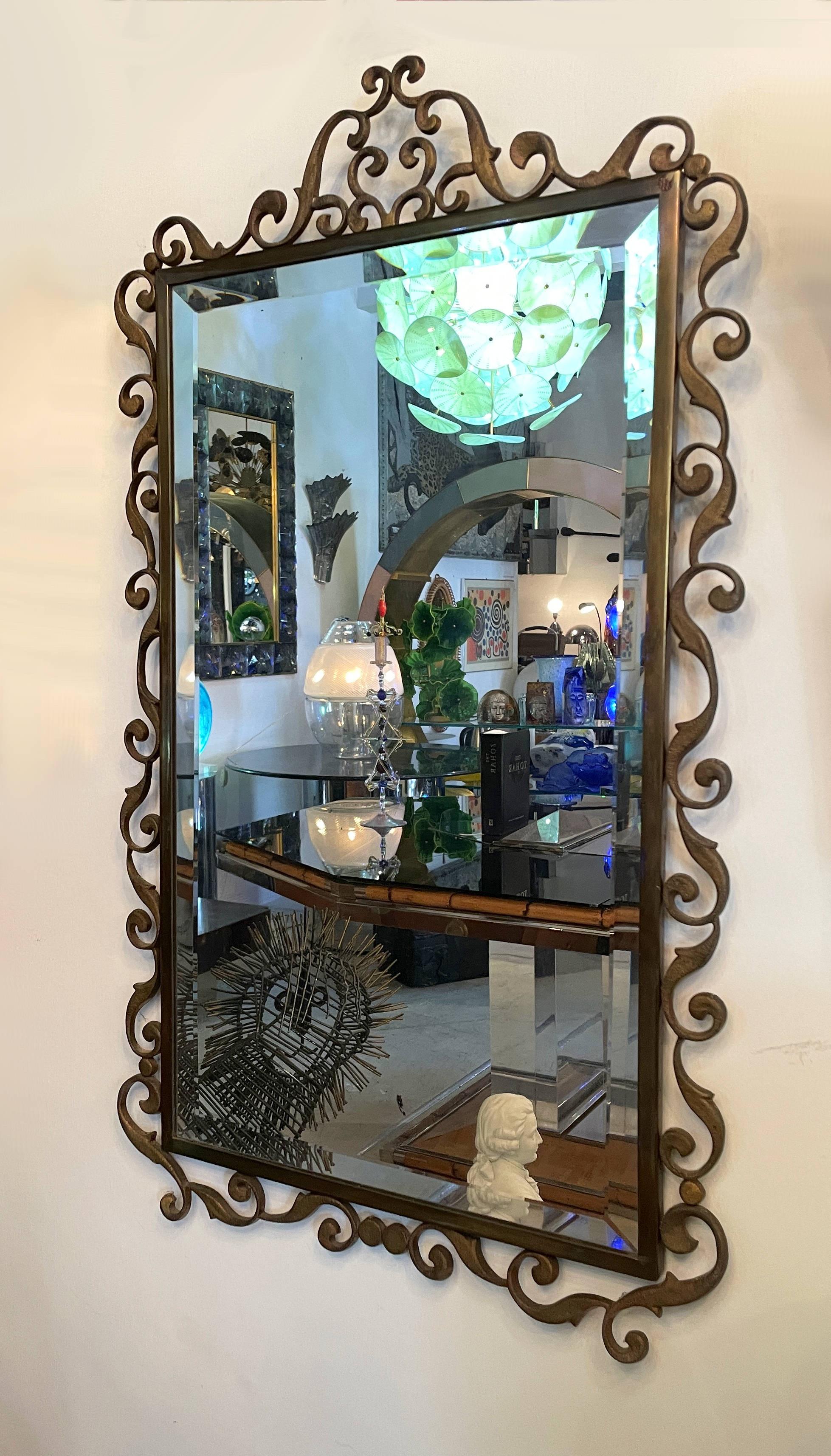 Very chic, yet ornate, bronze scrolling framed mirror. The bronze frame and scrolls are sturdy, heavy and of great quality. This elegant Italian treasure mixes well in modern, mid-century or old world interiors.