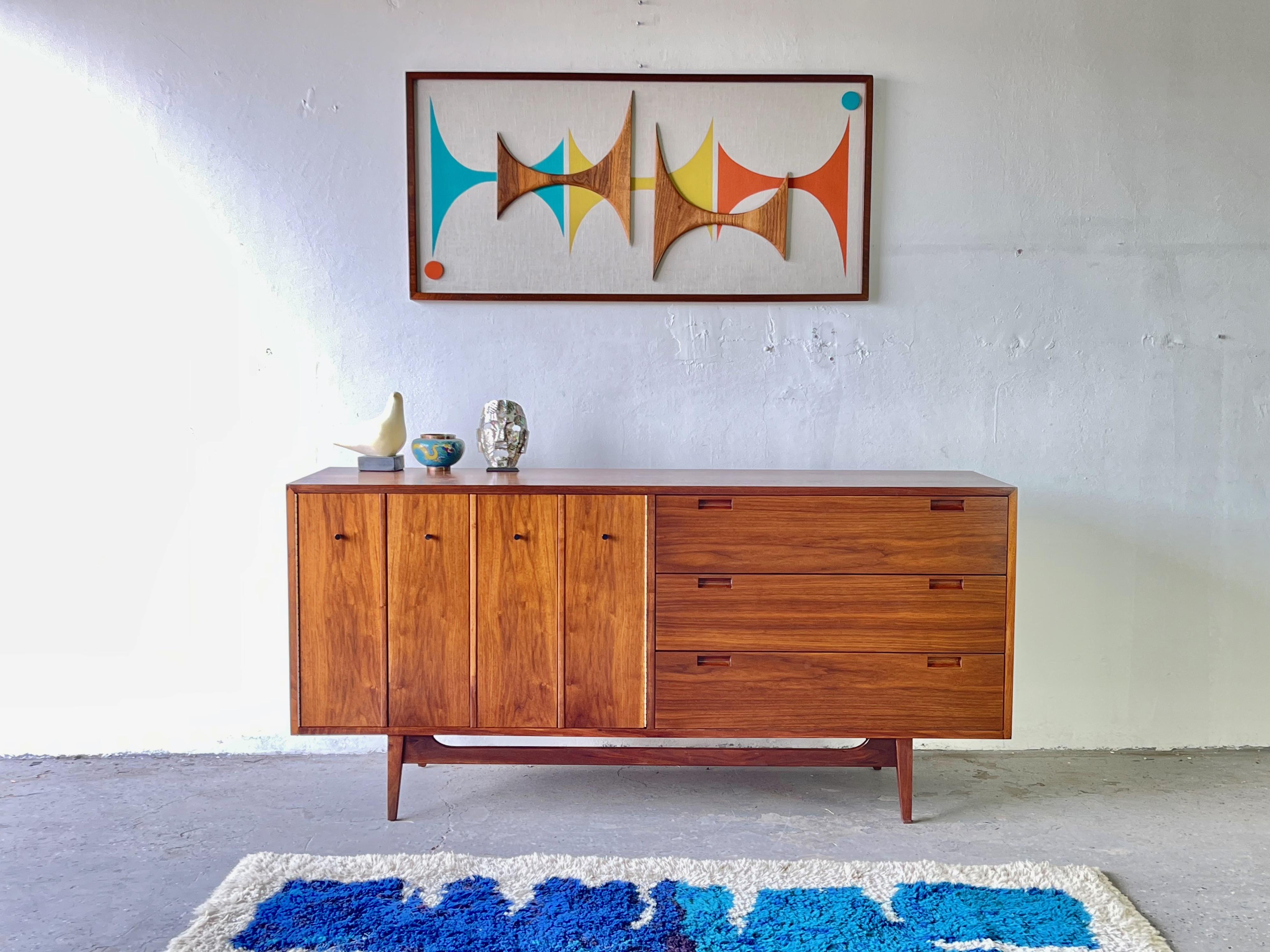 Stunning Mid-Century Modern American of Martinsville Walnut credenza 


Sophisticated and elegant American of Martinsville Walnut credenza with clean modern lines. The credenza features two accordion doors which reveal two adjustable shelves,