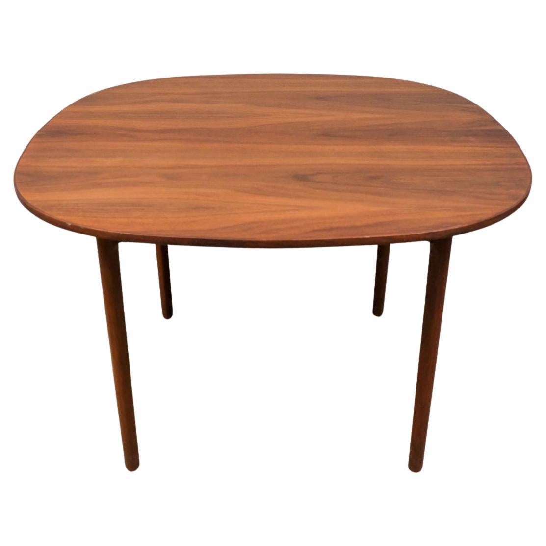 Mid century modern danish teak rounded dining table with two leaves. This table sits on (4)  tapered legs and has brass hardware under the table. This table sits 4 - 8 chairs. Beautiful woodgrain clean all around. Made in Denmark. Located in