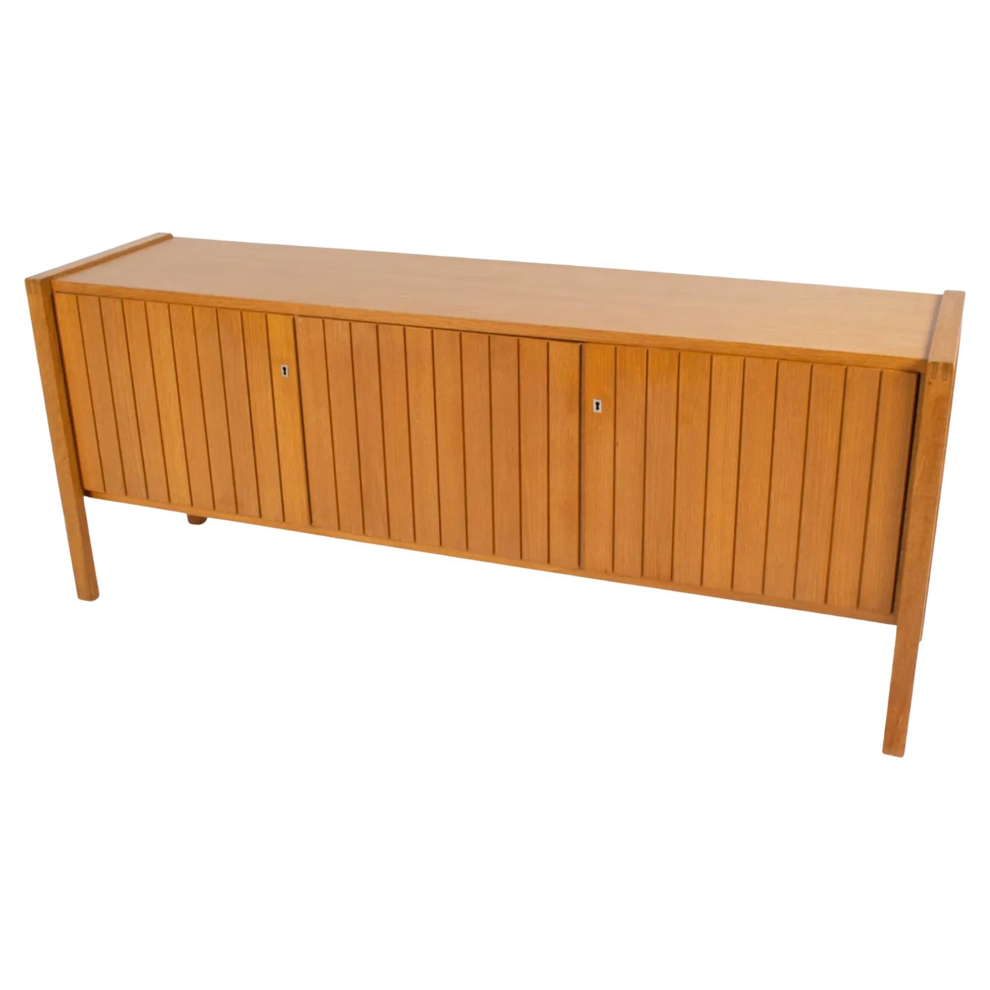 Mid Century modern German Oak Paneled Credenza 3 door with key. Beautiful Modernist design simple and high end woodworking. Has 3 doors with 2 locks. Comes with a key. Made In Germany circa 1960 - Located in Brooklyn NYC. Very Clean and Ready for
