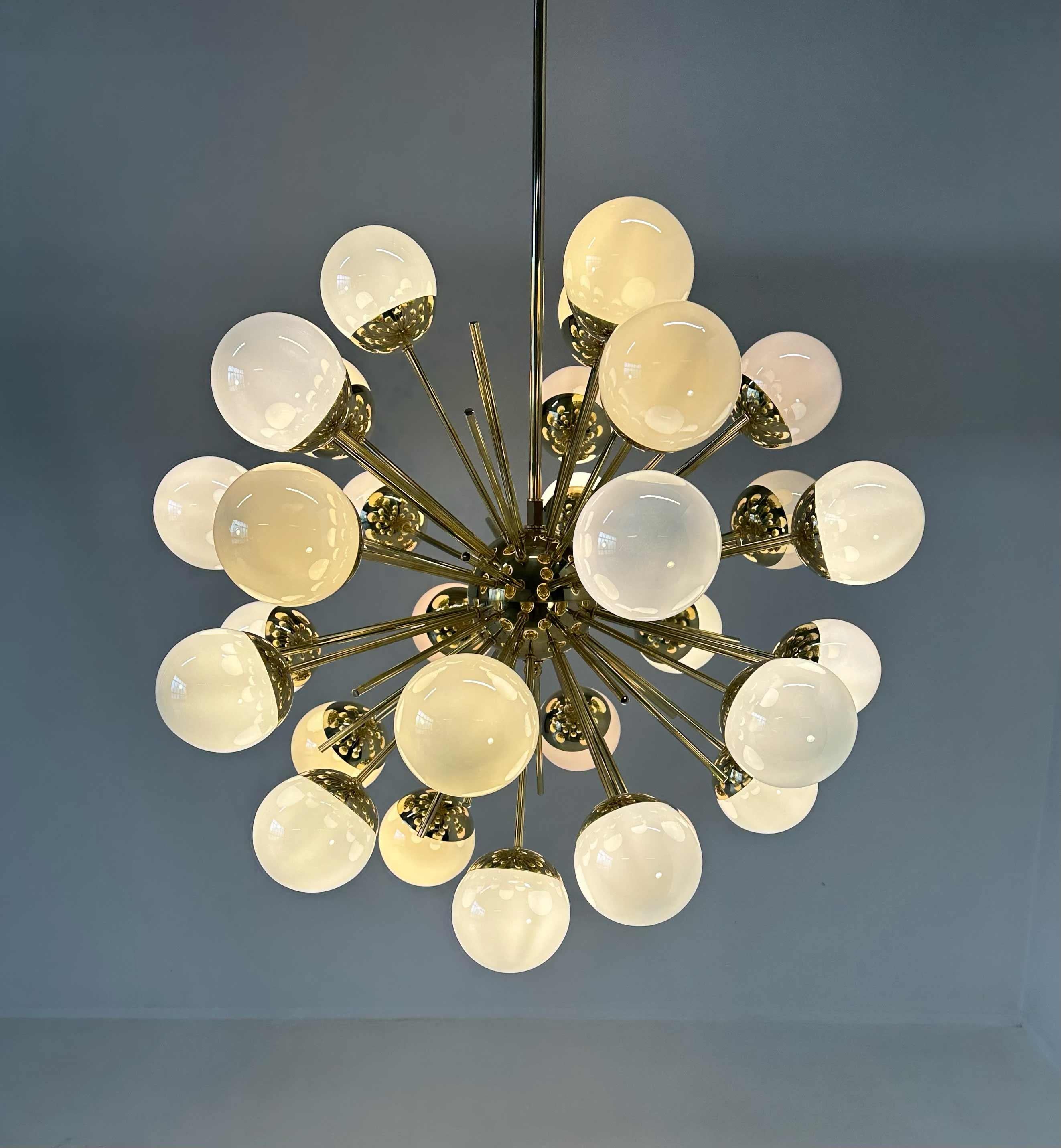 Ce lustre a été produit à Murano dans un style mid-century et il est composé de 30 sphères irisées en verre tandis que la structure est en laiton.
Des conditions parfaites.