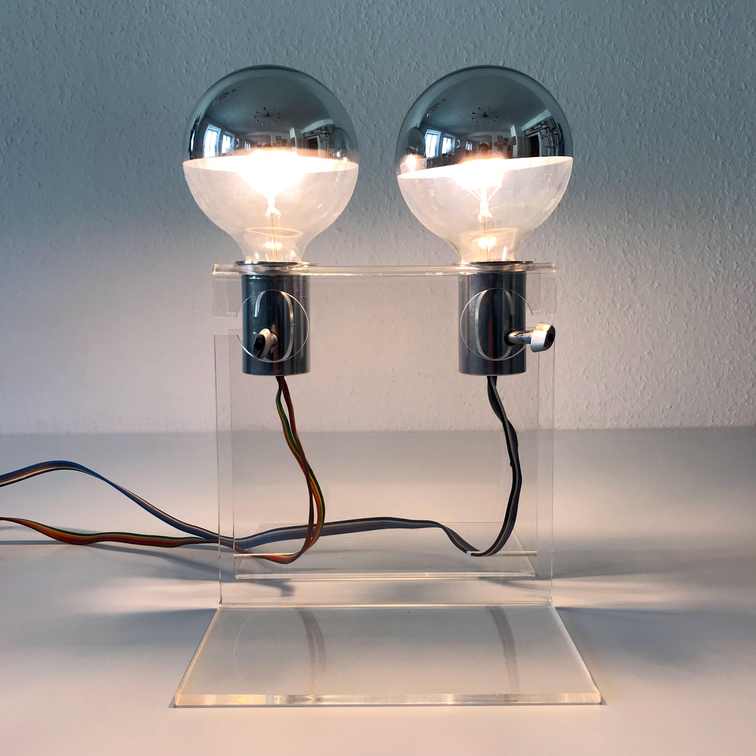 Unique Mid-Century Modern table lamp. Designed and manufactured probably in 1970s, Germany.

The base is executed in clear plexiglass. The lamp has 2 x E27 screw fit bulb holders. Better run with big globe bulbs. It is wired, in working condition