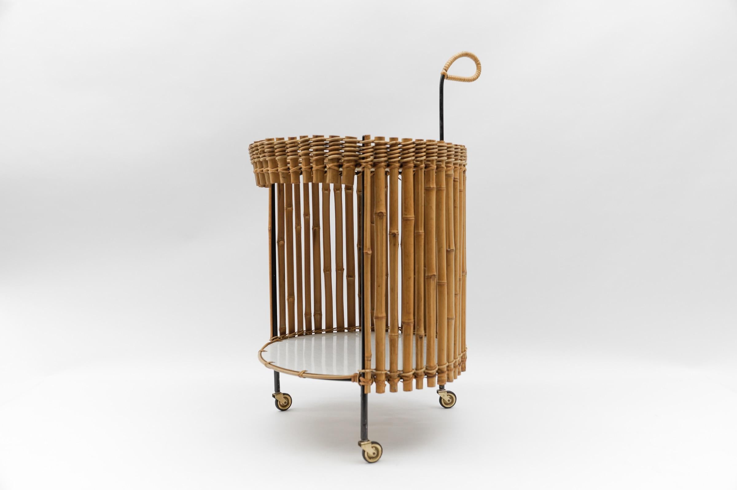Stunning midcentury round serving cart in bamboo and metal. This unique piece was produced in Austria in the 1950s.