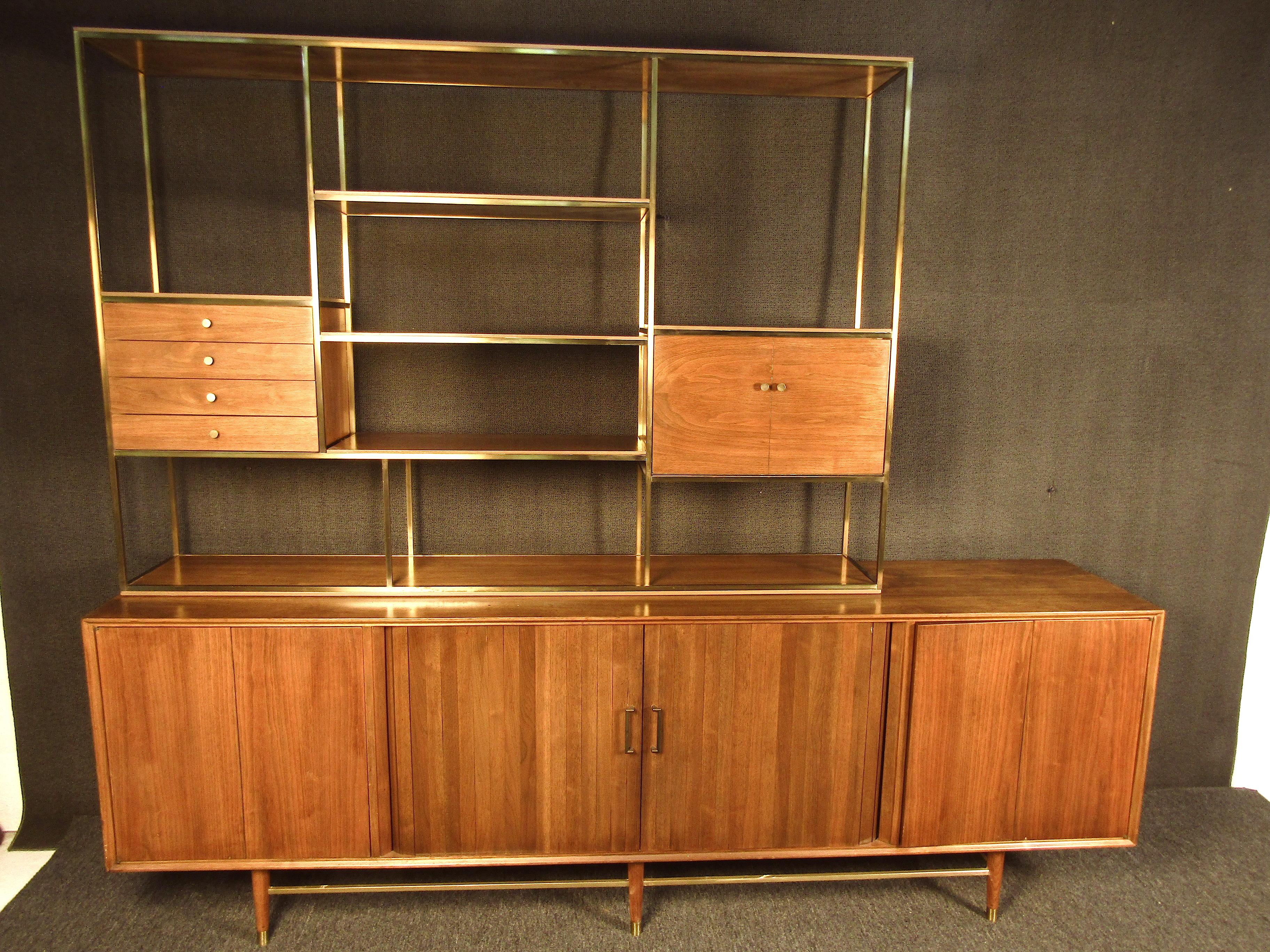 This beautiful wall unit boasts impressive size with style to match. Featuring deep wood grains and brass accents along with plenty of storage space this piece is both stunning and functional. Perfect for any dining room or entertainment space.