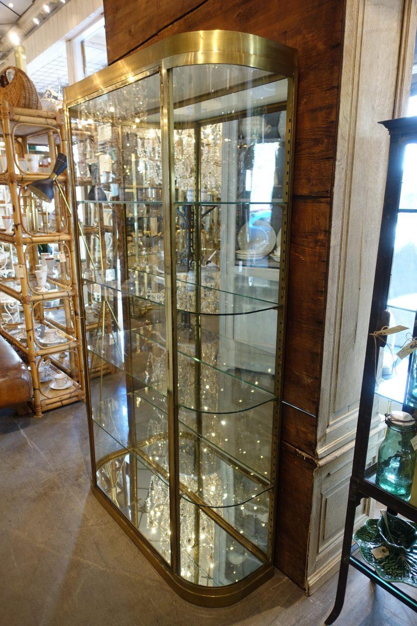 Stunning and well-proportioned midcentury French showcase / Vitrine. Beautiful sleek details and profiles, as well as elegant stylish curved glass corners. Brass framed, equipped with key and locking gear, 4 beautiful rounded glass adjustable