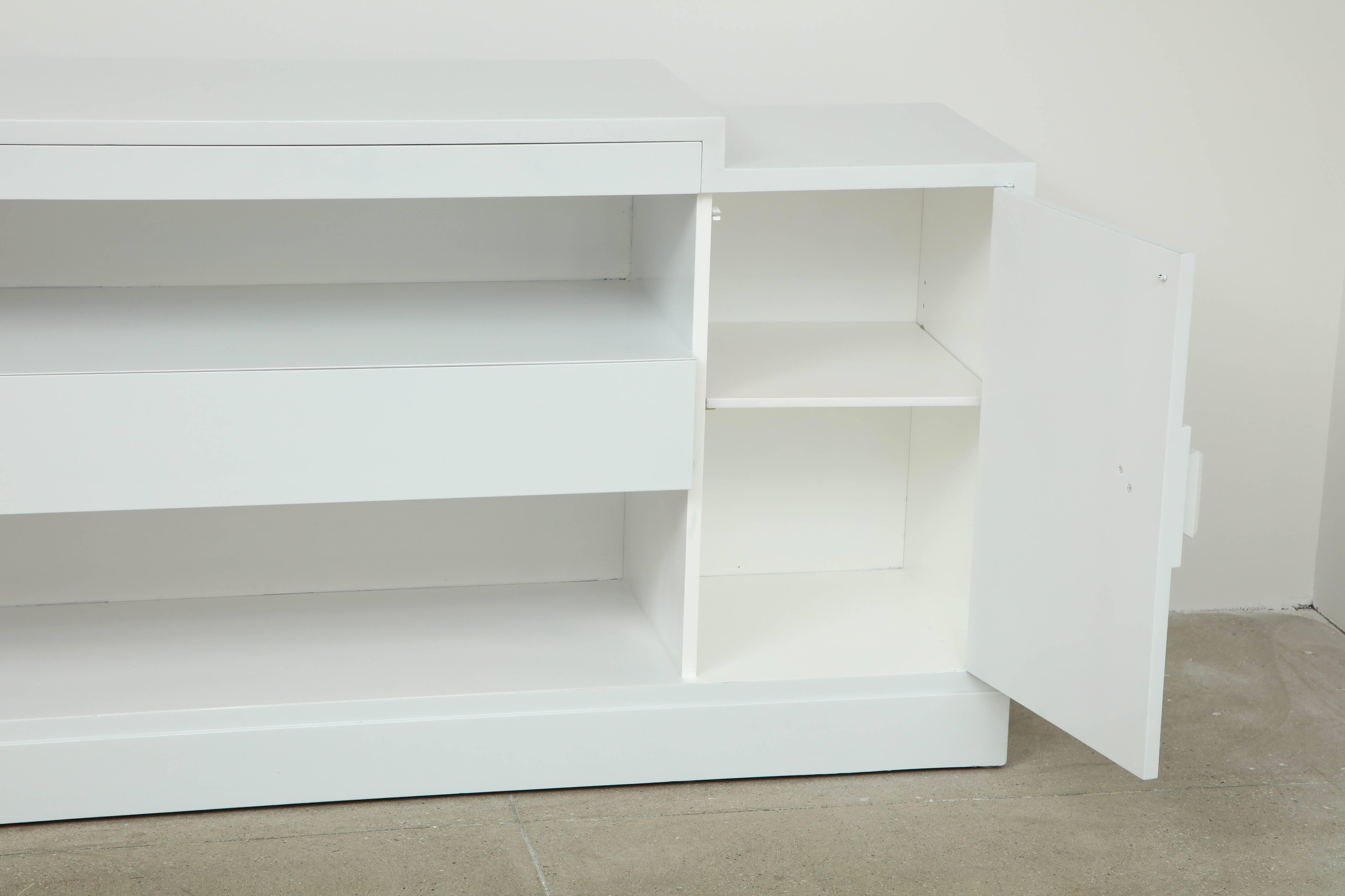 Stunning Minimalist cabinet by James Mont.
The cabinet has been  refinished in a high gloss white lacquer.
The lacquered doors are accented by the silver leaf 