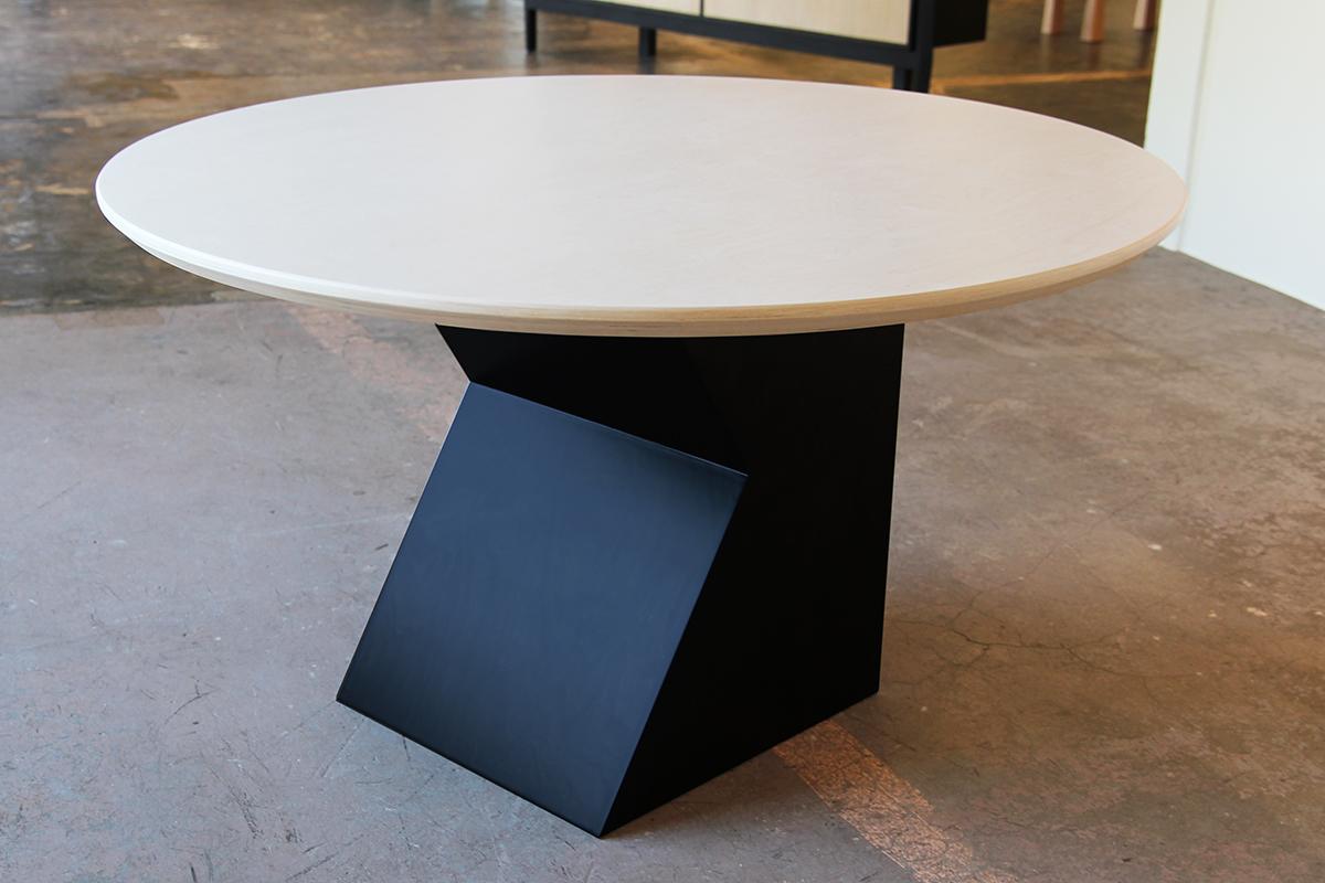 Custom Reeves Art + Design natural wood and black stain contemporary dining table with geometric base. The table features a circular wood top and is paired with a black geometric base, balancing the overall soft and sharp elements of this