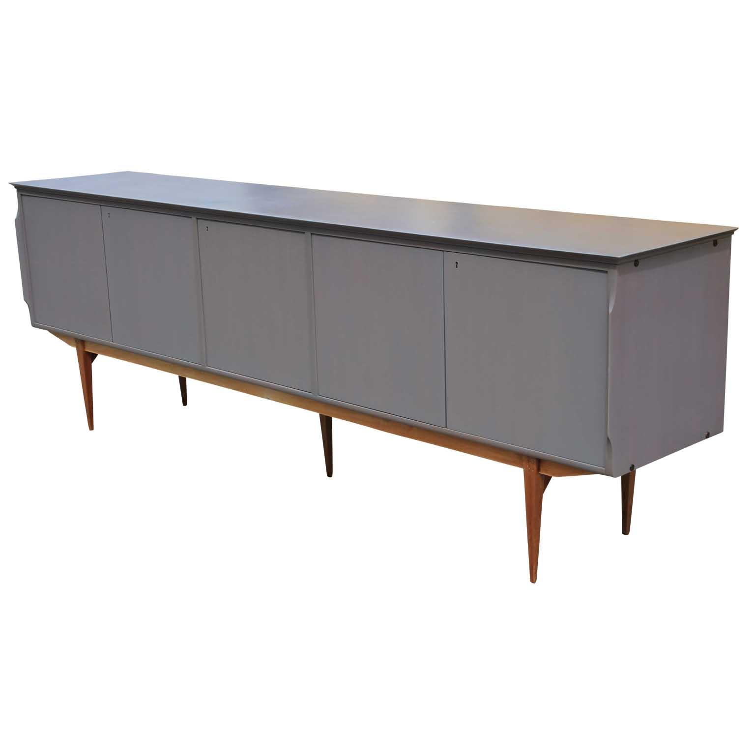 Wonderful restored Italian modern sideboard, circa 1950. The extra long sideboard had been refinished in a light grey stain while leaving the legs natural. The interior has been left original as the wood tones were quite beautiful. A show stopper in
