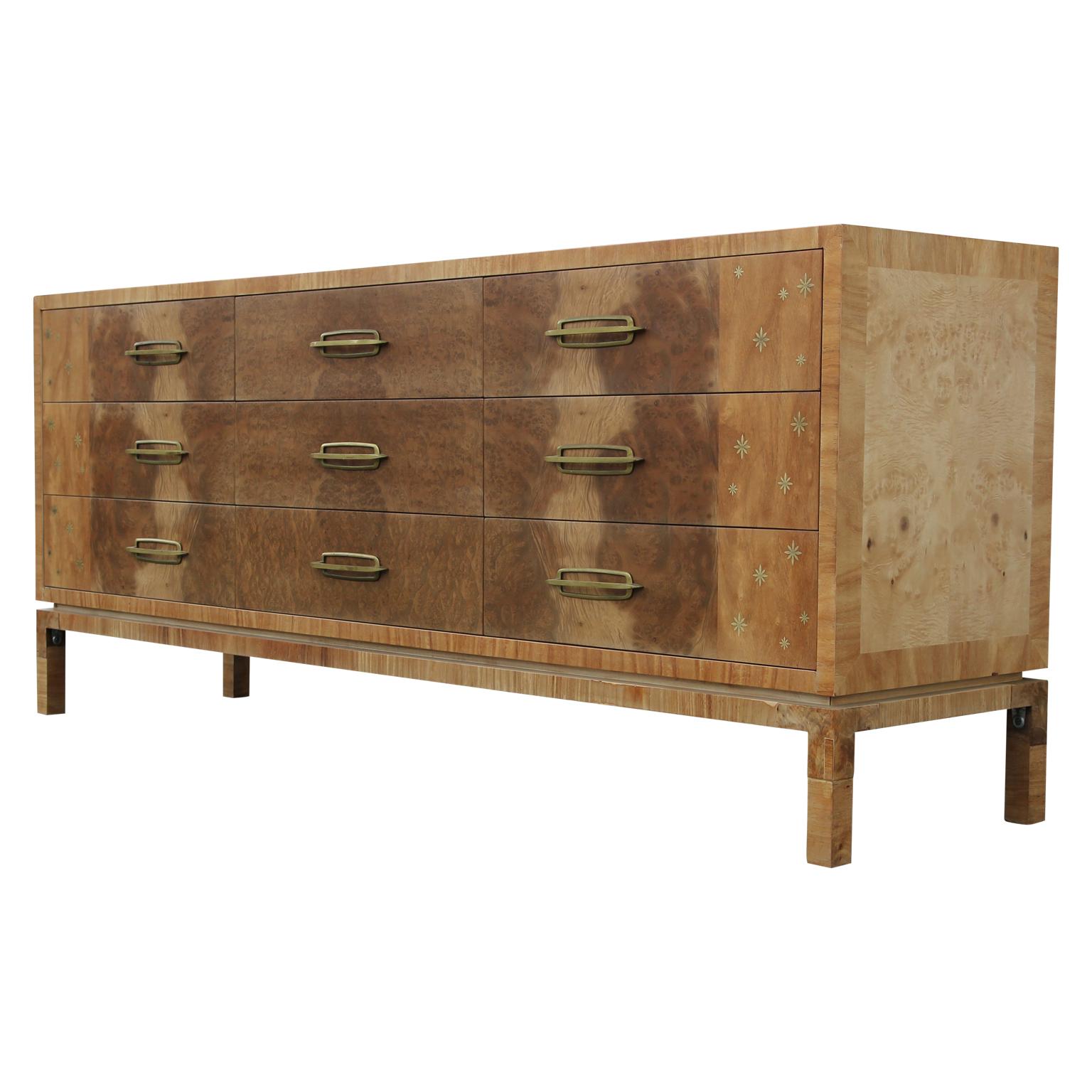 Rare and unique multi functional dresser or sideboard with nine drawers. The dresser features inlayed brass stars and brass handles. The dresser is made from light burl wood and was created Romweber Furniture. Designed by Harold Schwartz. Fully
