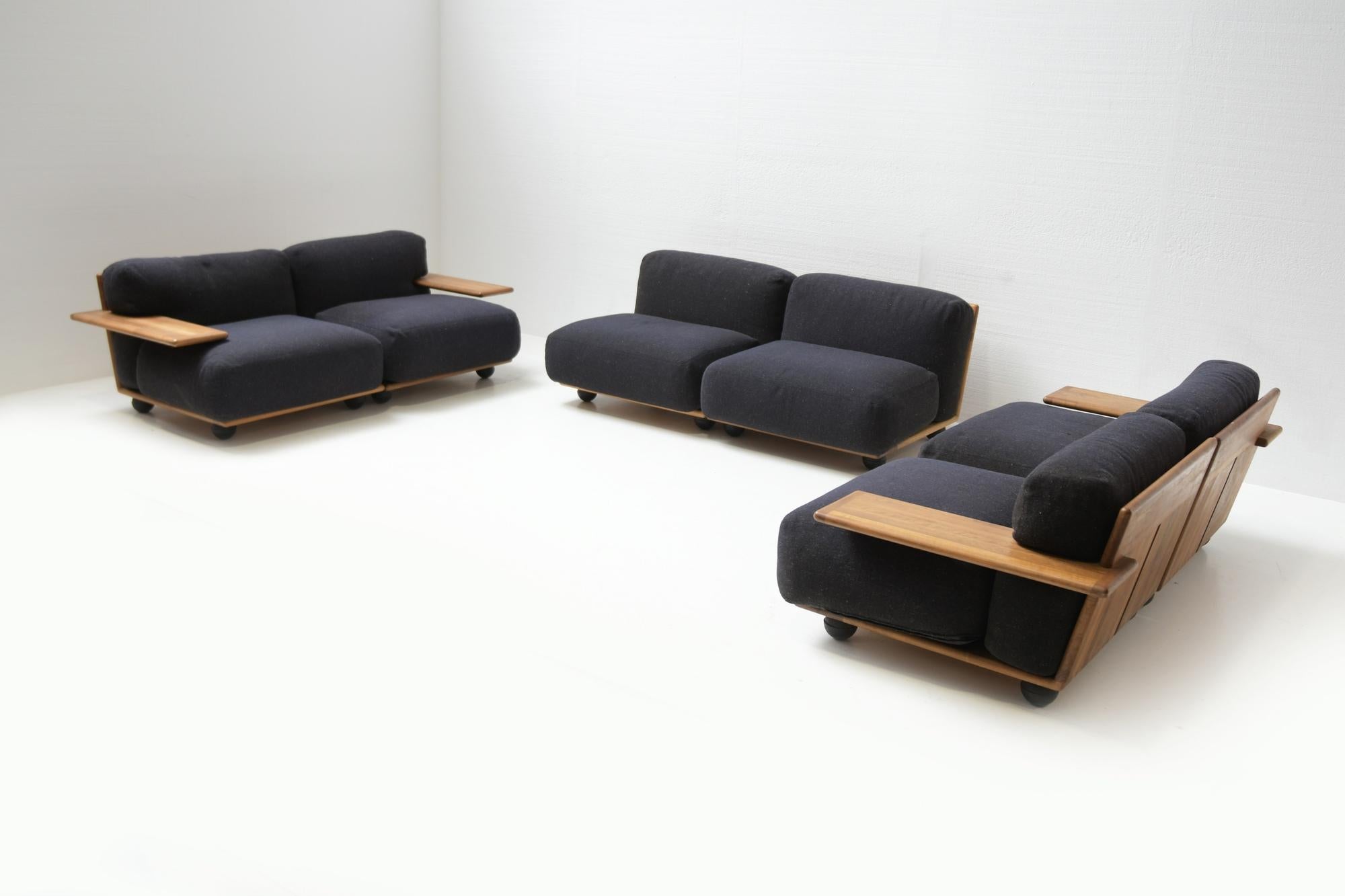 Stunning, rare & complete Pianura seating group by Mario Bellini for Cassina in the 1970s. 
Solid walnut wooden frame. The cushions still have their original fabric. The color is dark blue / dark grey.

This set contains 2 modular 3 seater sofa’s