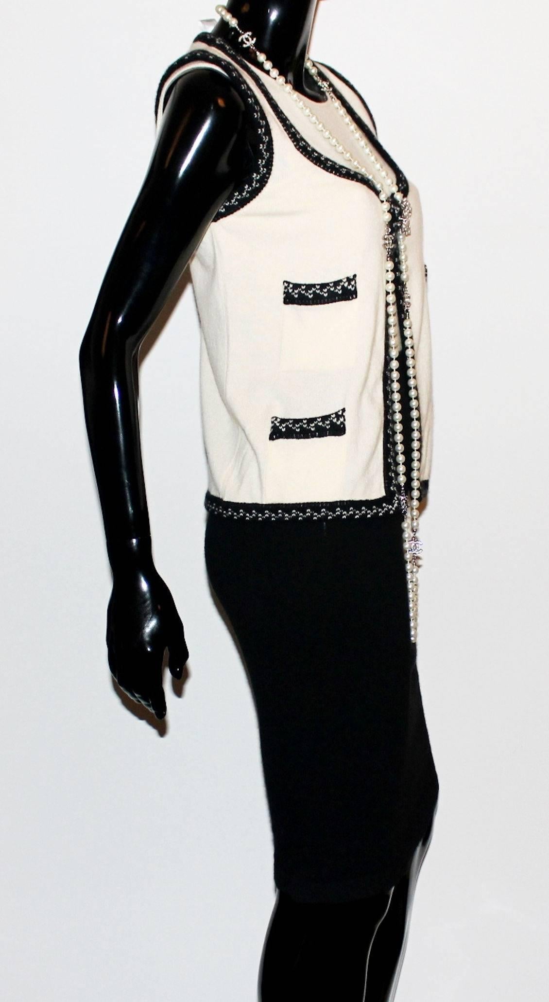 Black and Ivory Chanel Cashmere Dress Set
Consisting of two pieces, dress and gilet
Bodyhugging dress 
Simply slips on
Matching gilet vest
Closes in front with hidden push button
Amazing crochet trimming
Front pockets
CHANEL logo plate on front
100%