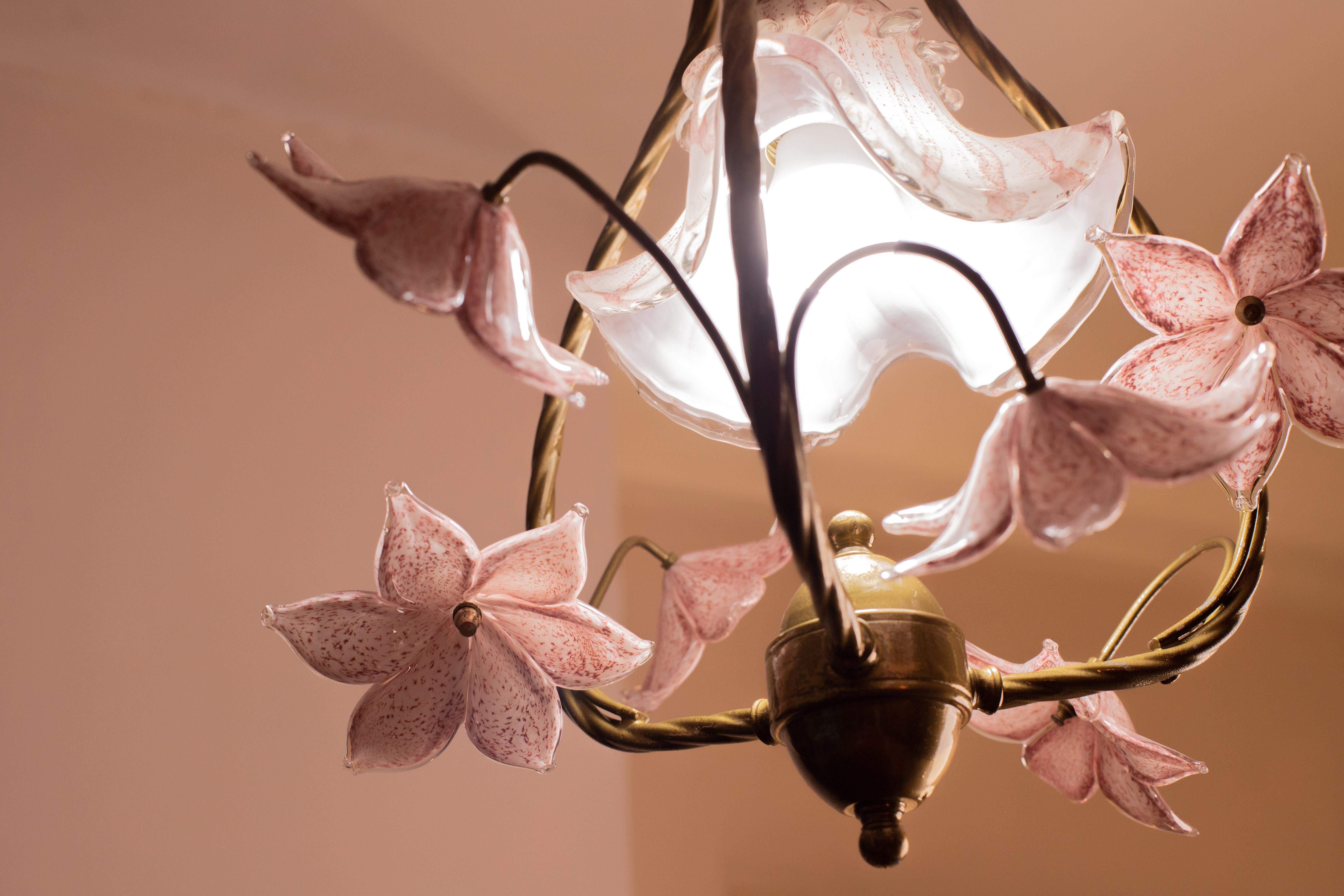 Stunning Murano chandelier with 6 pink flowers and one central pink glass element.
The chandelier consists of 6 pink flowers and the structure has been bronzed lacquered.
The chandelier has 1 E27 light points.
The chandelier measures is 110 cm