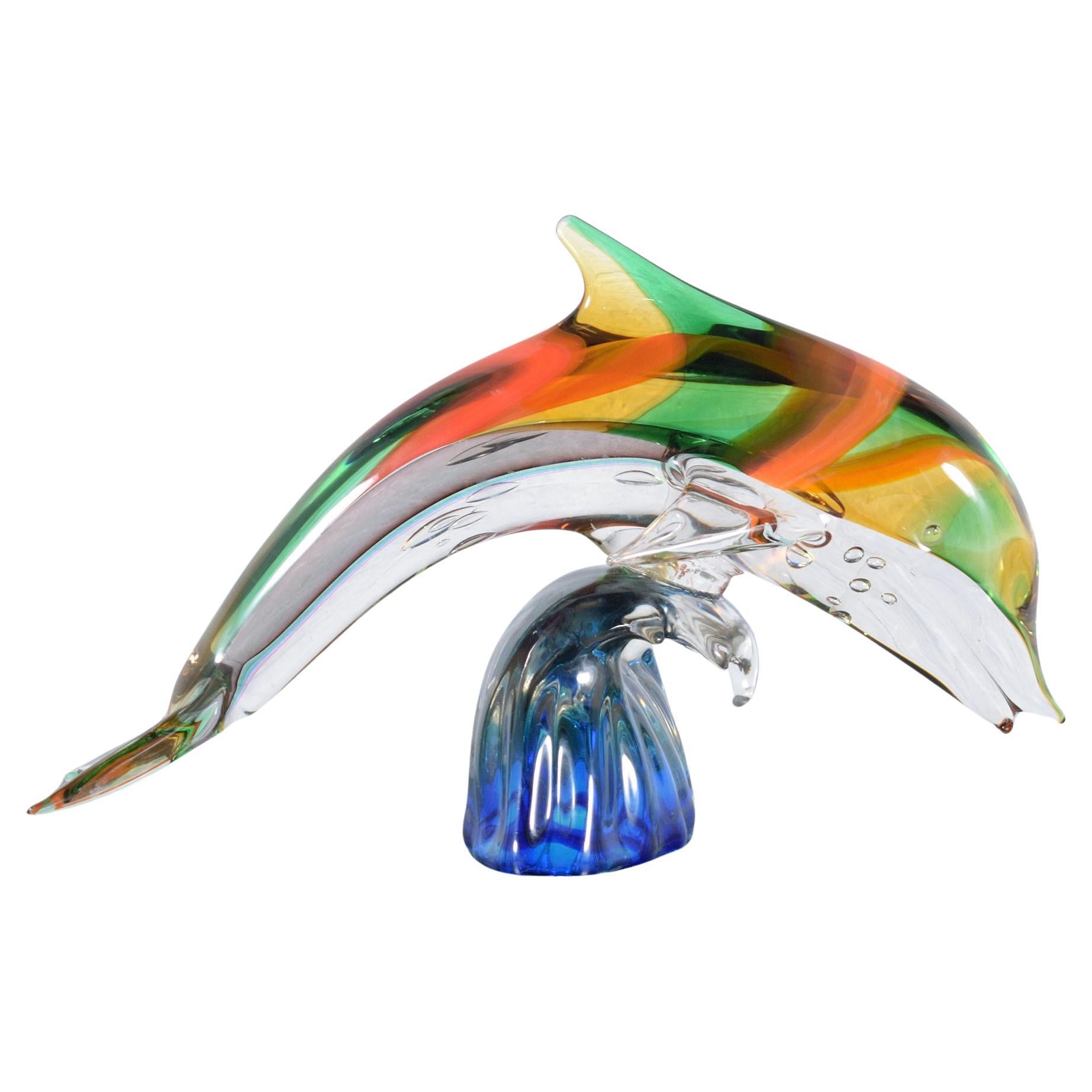 Umarmen Sie die Schönheit des Ozeans mit unserer atemberaubenden Delphin-Skulptur aus Murano-Glas, ein wahres Meisterwerk der aquatischen Eleganz. Dieses exquisite Stück zeigt die berühmte Handwerkskunst der Murano-Glaskunst, die für ihre lebendigen