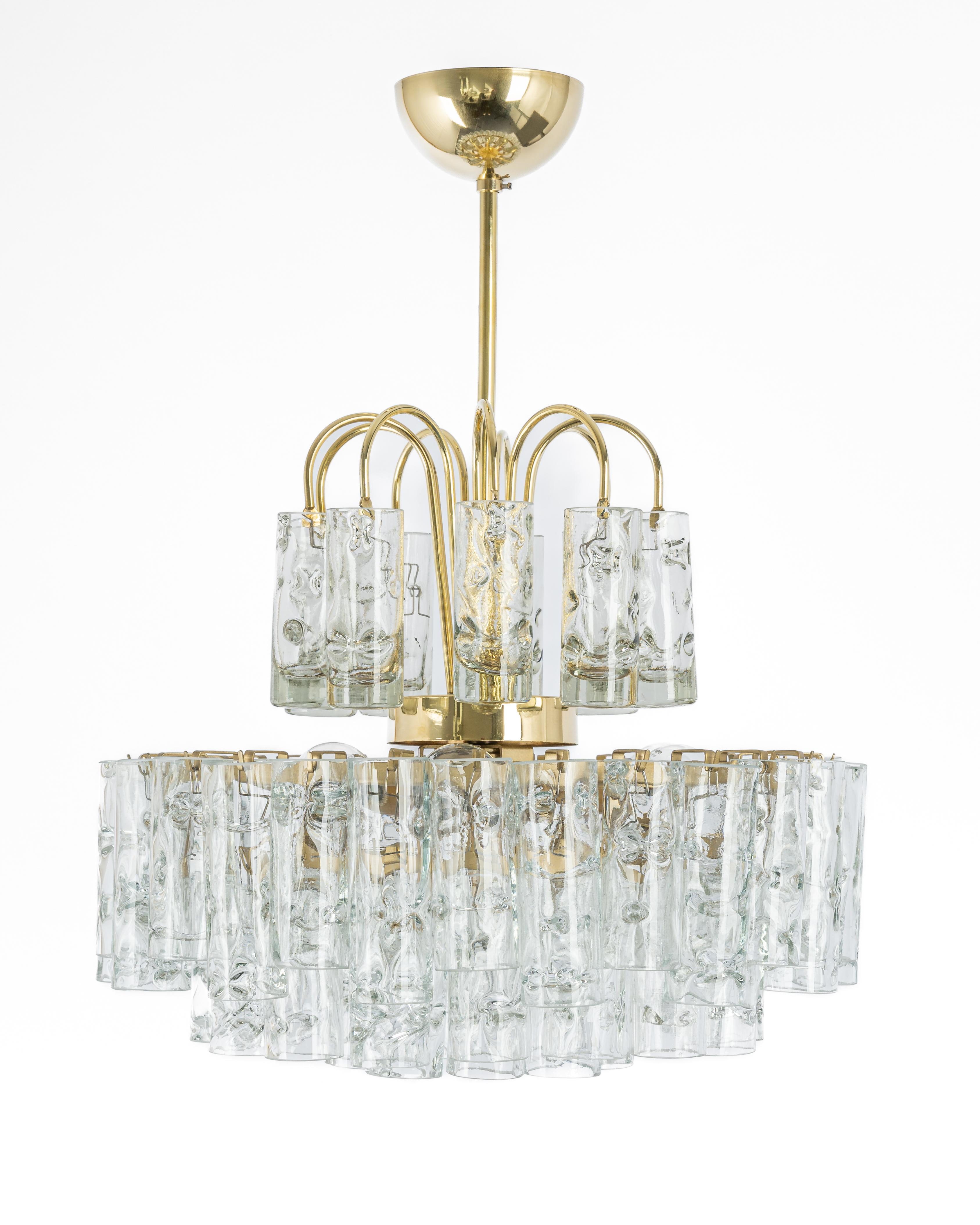 Fantastic four-tier midcentury chandelier by Doria, Germany manufactured, circa 1960-1969. Murano glass cylinders suspended from the fixture.

High quality and in very good condition. Cleaned, well-wired and ready to use. 

The fixture requires