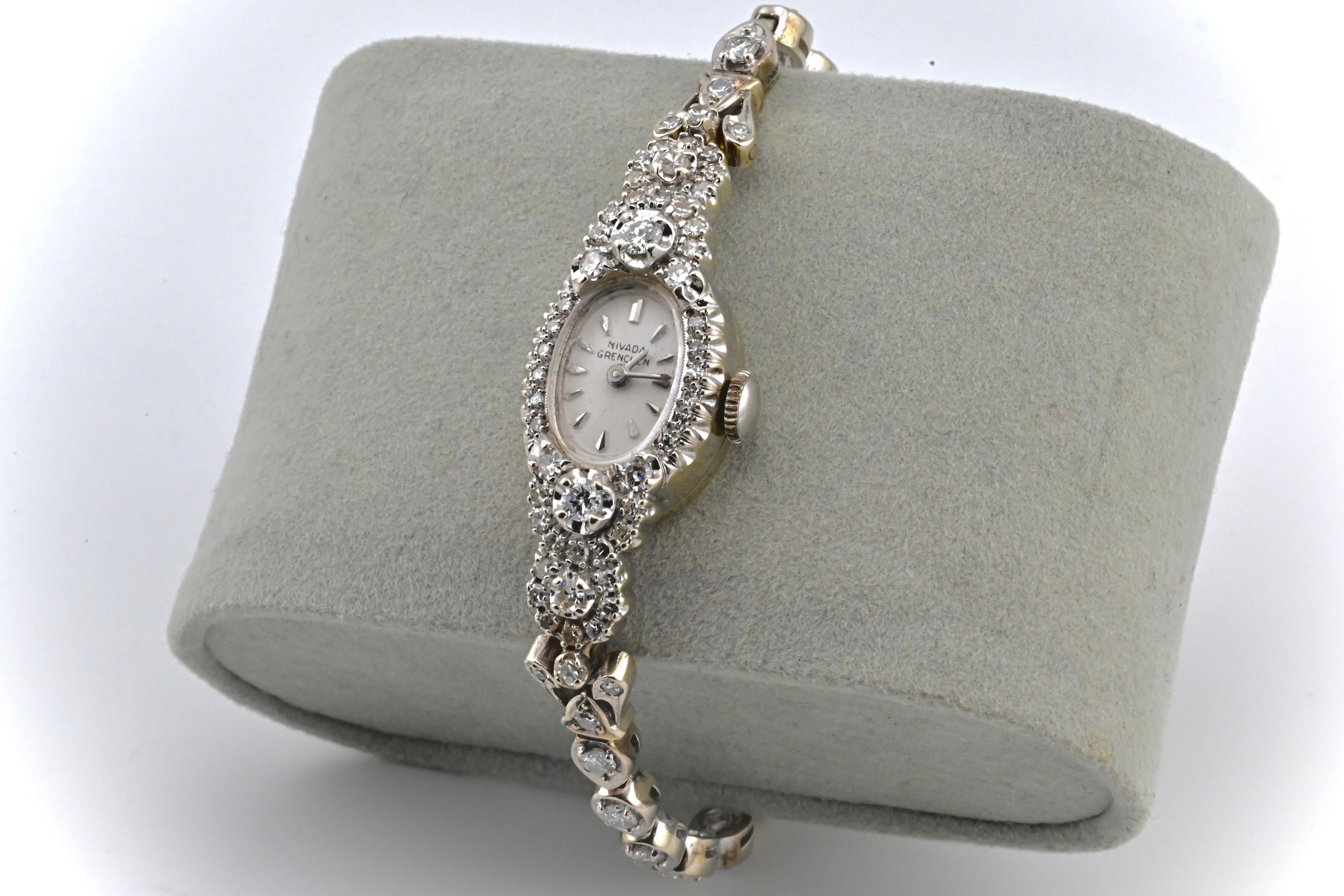 Dies ist eine absolut atemberaubende Nivada Grenchen Damenarmbanduhr mit 14k Weißgold & Diamanten gemacht. Diese Uhr hat eine wunderschöne, mit Diamanten besetzte Lünette und hochwertige Diamanten im Rundschliff, die über das Armband der Uhr laufen.