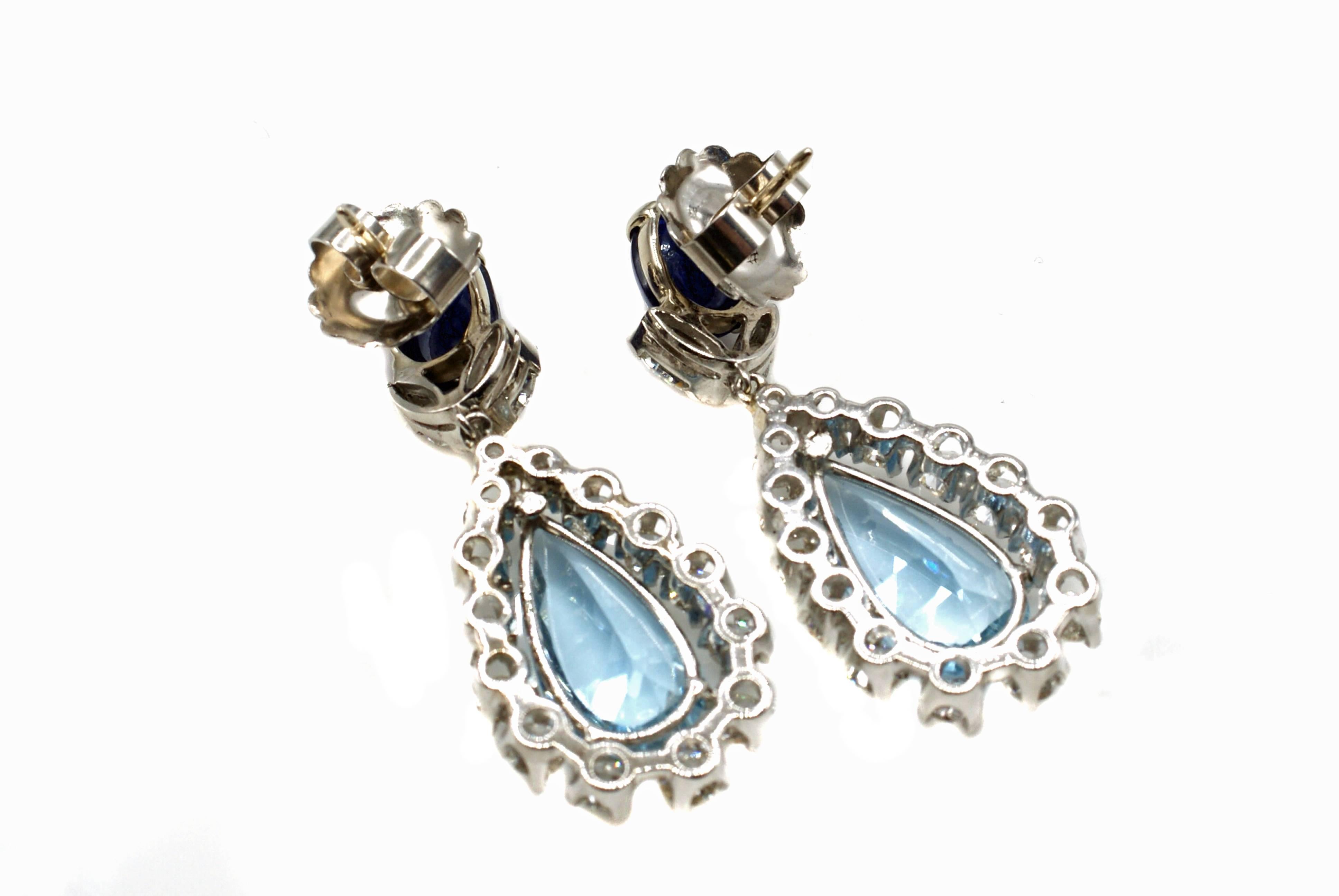 This pair of stunning and chic hand-crafted platinum earrings from ca. 1940 are set with 2 Burma no-heat cabochon sapphires on the top of the and 2 lively and brilliant sky-blue pear-shape aquamarines on the bottom. The certified sapphires have a