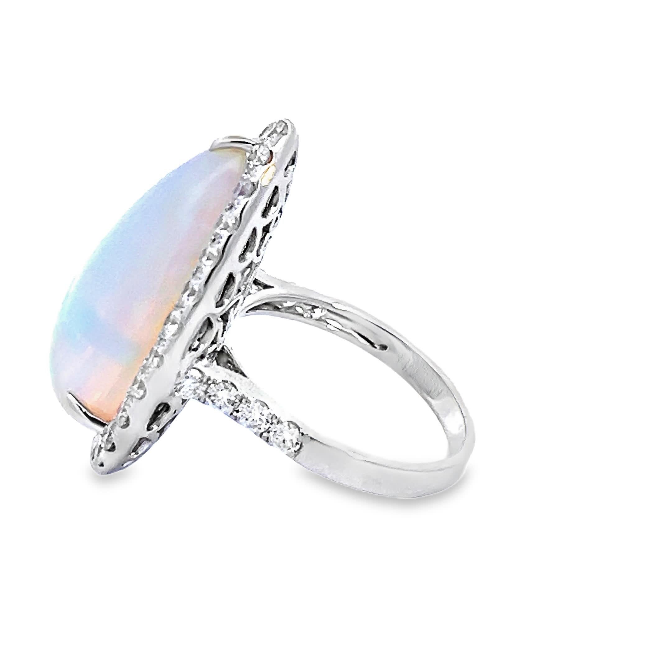 Dieser exquisite Ring zeigt einen faszinierenden tropfenförmigen Opal in der Mitte, umgeben von einem Heiligenschein aus funkelnden Diamanten. Die schillernden Farben des Opals changieren wunderschön im Licht und machen ihn zu einem fesselnden Stück