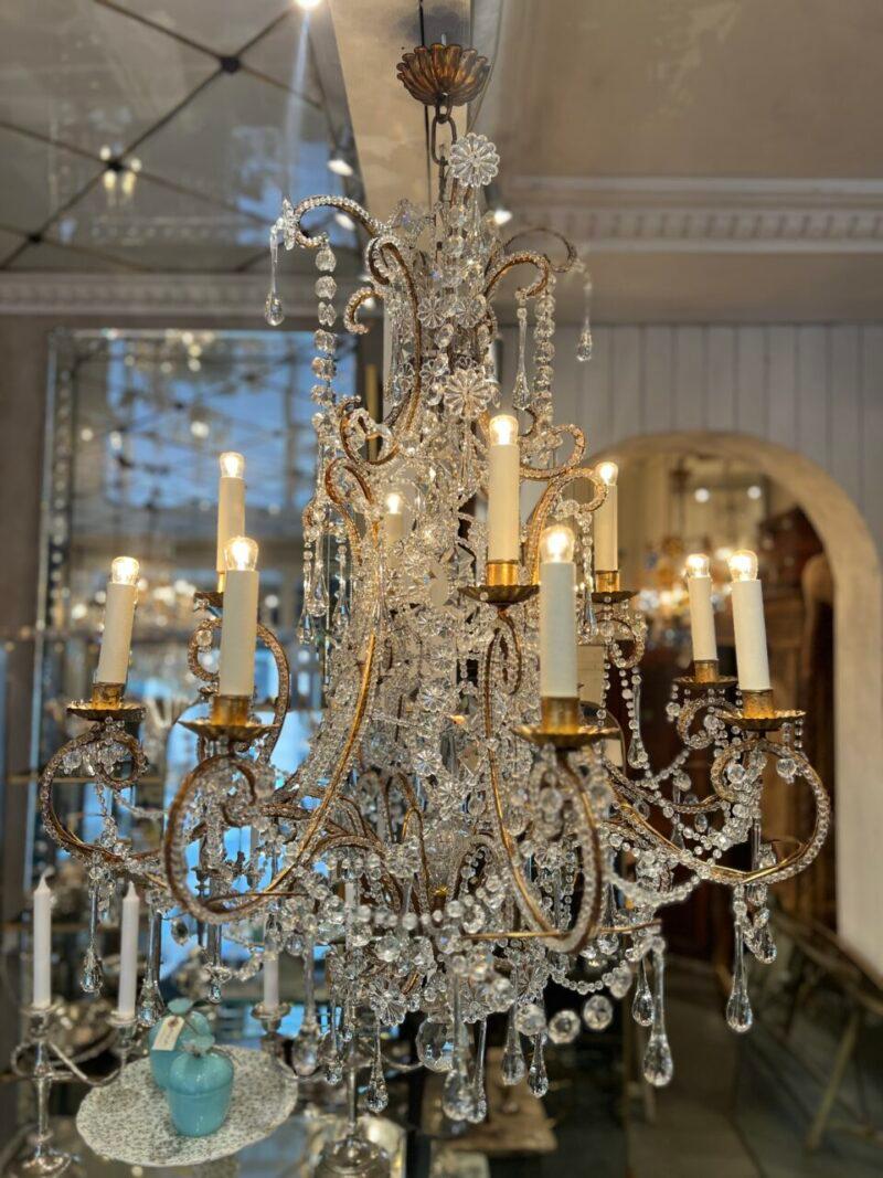 Stunning and opulent cage-shaped prism chandelier from Italy circa 1900.

This large and luxurious piece is formed in gilded metal, and has 12 lights, staggered over 2 levels.

The frame is decorated with small, charming glass beading and the