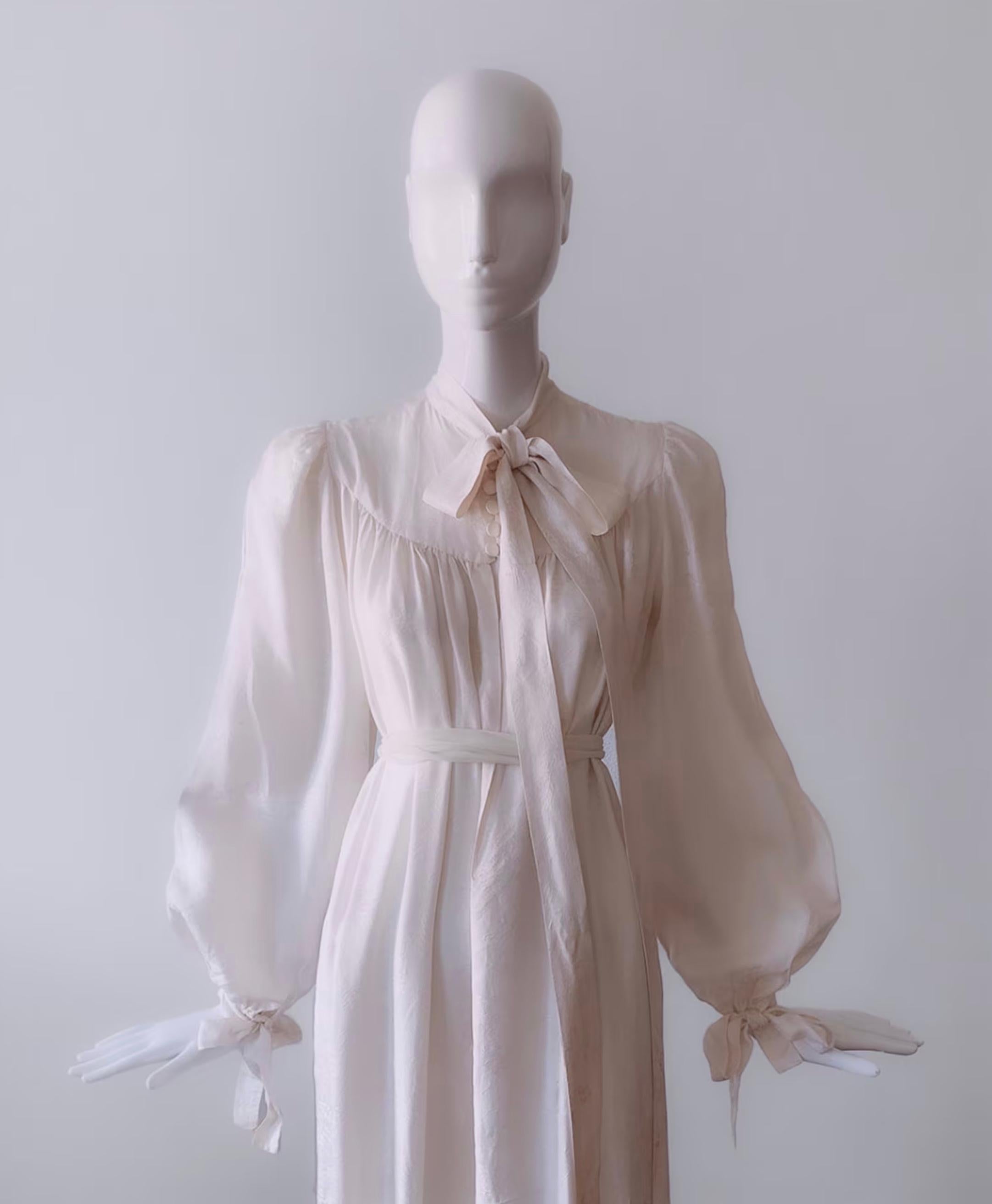 
Stunning extremely rare creation by Fashion Icon Jean-Louis Scherrer. The softest liquid pure silk. Long maxi dress designed in the free spirit of the 1970s: Beautiful long cascading floaty shape with big puffy poet sleeves that tie in bows and a