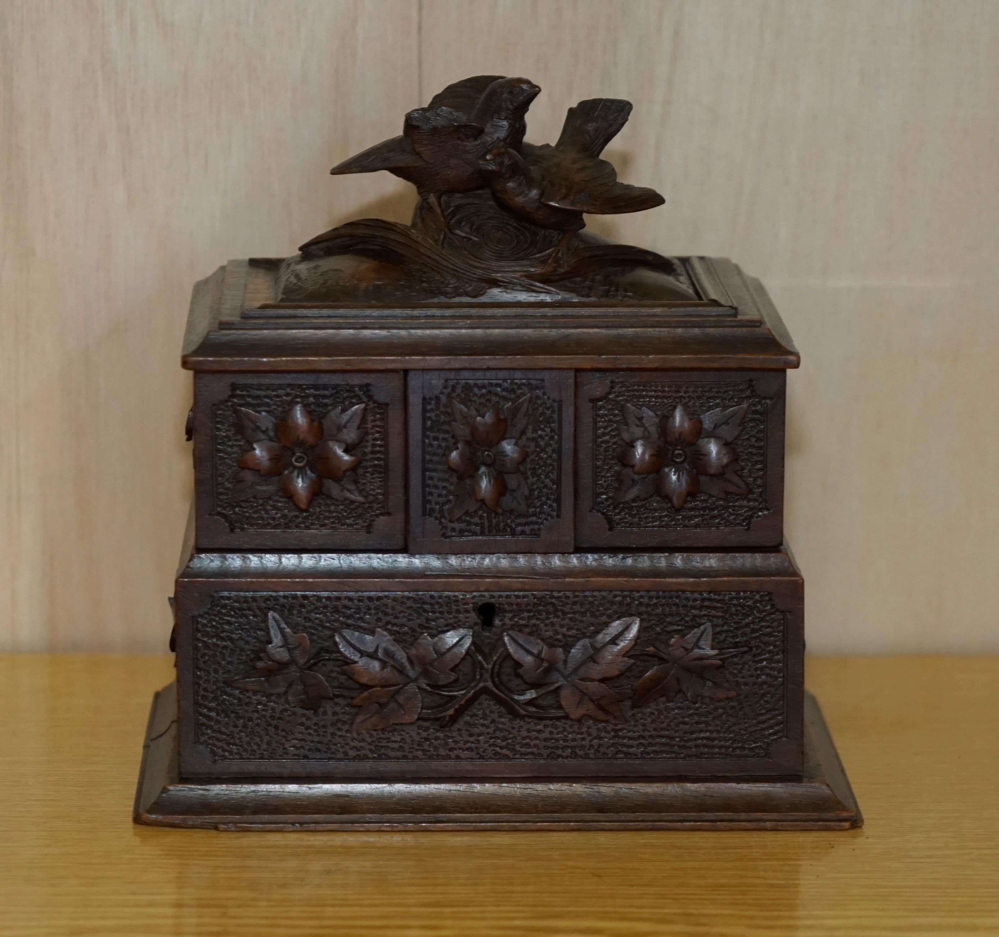 We are is delighted to offer for sale this rather lovely antique original circa 1880 black forest wood jewellery box

A very good looking and well made piece, it is hand carved all over with birds and floral decorations, the insides are blue silk